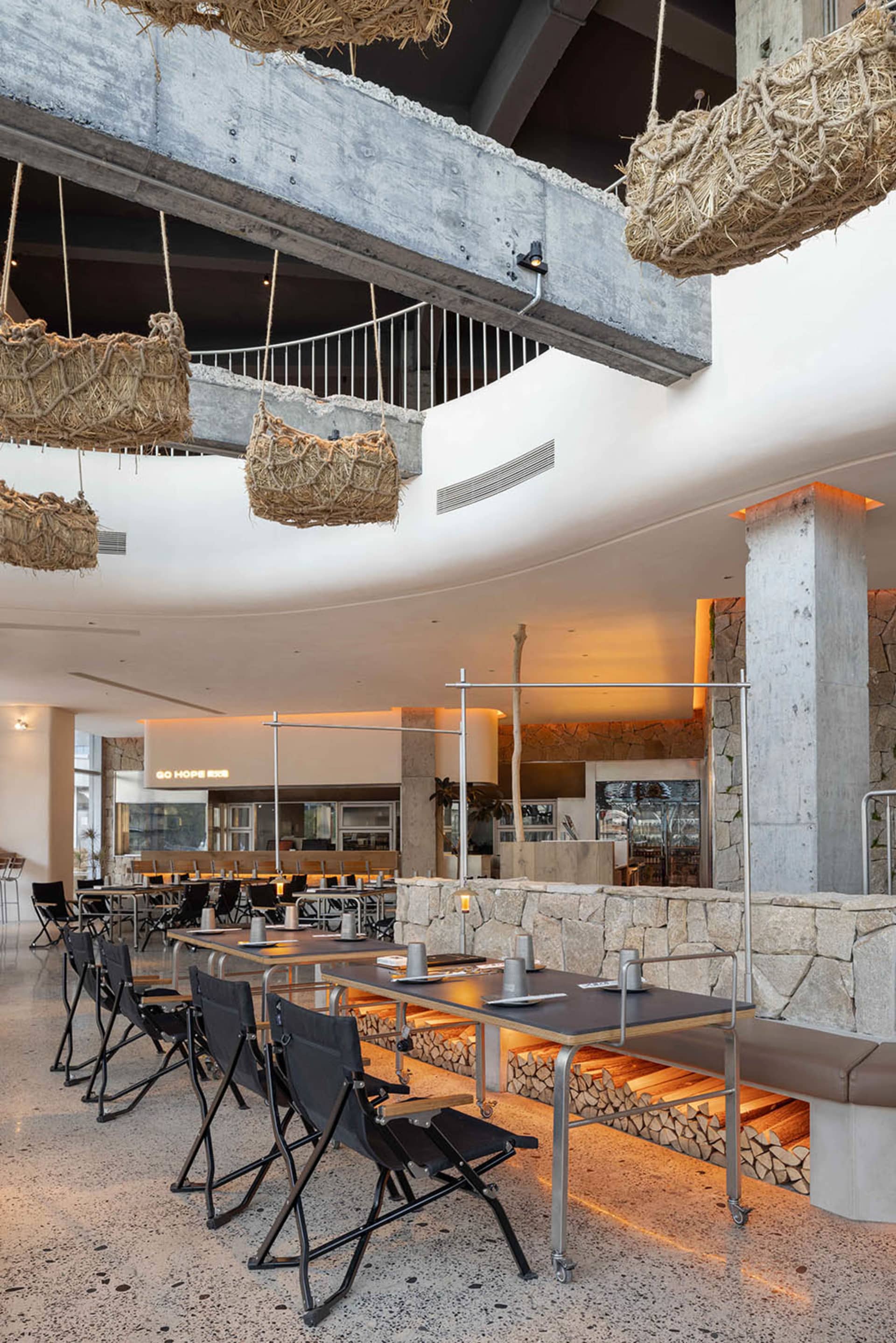 A modern dining space with a circular table surrounded by chairs, providing a comfortable atmosphere for guests, with well-thought-out lighting and a warm ambiance