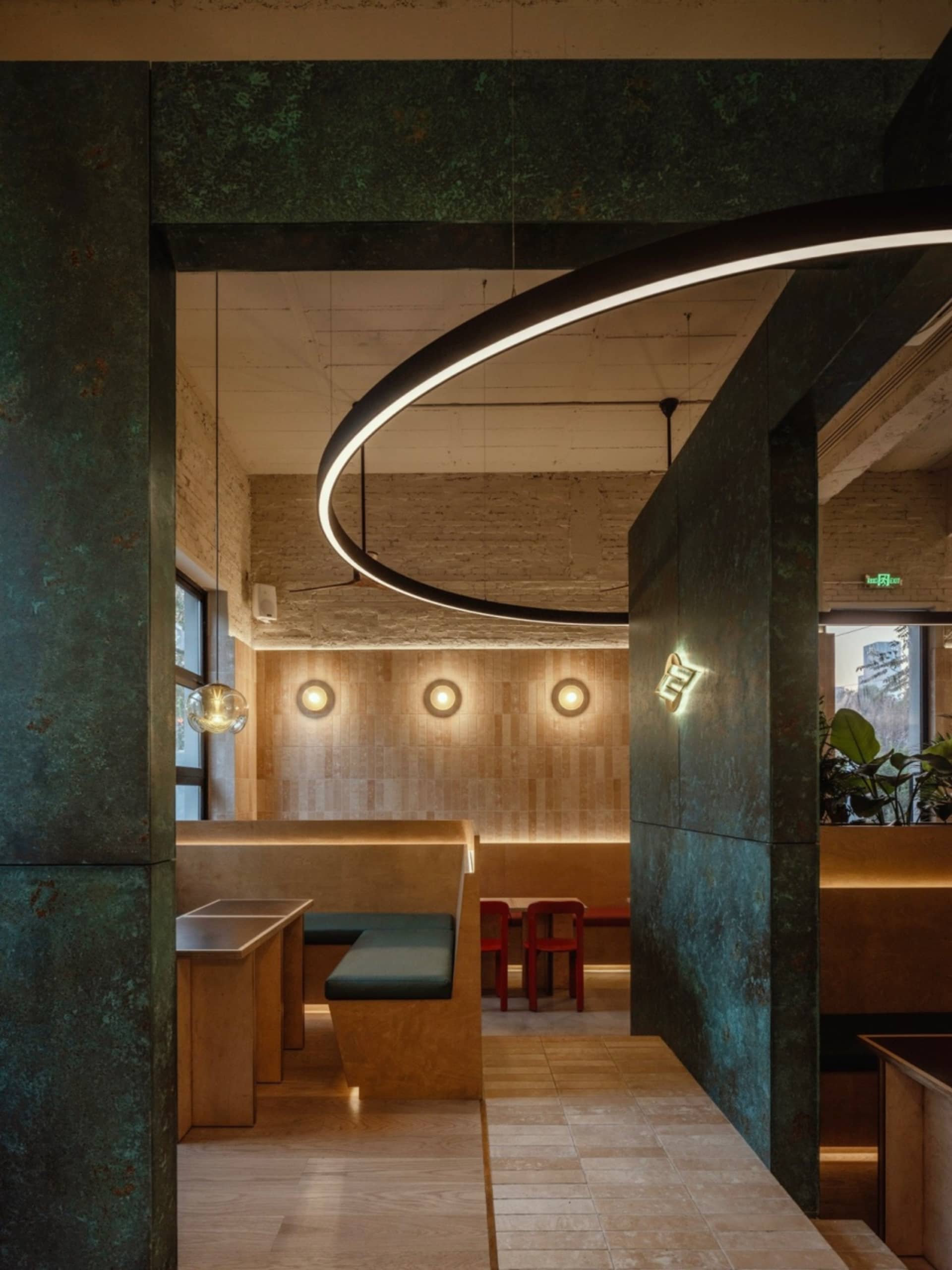 Dining area with chairs and tables, potted plants, metallic walls, and overhead lighting