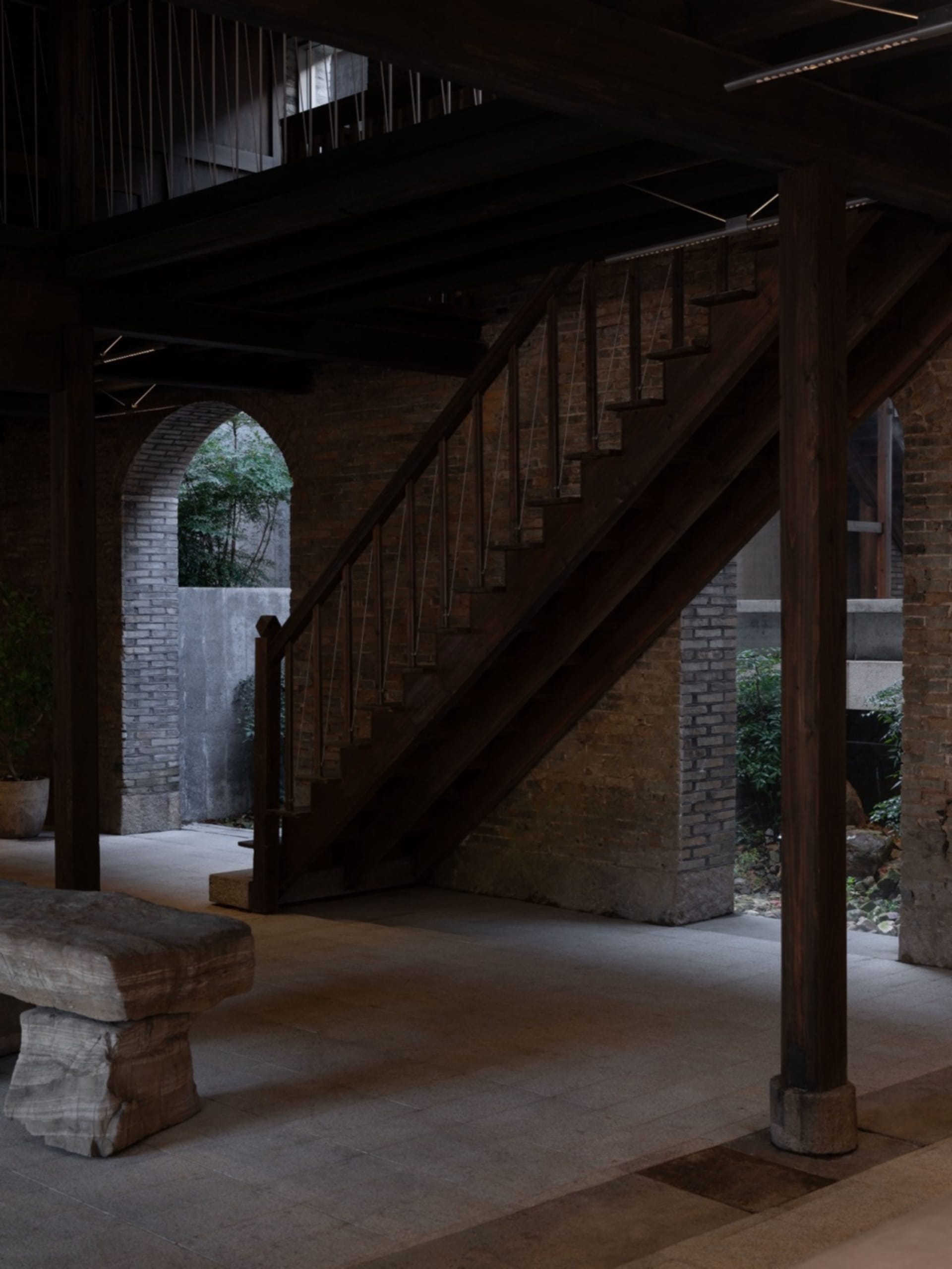 A stone building with a wooden staircase and a bench, suggesting a traditional European setting