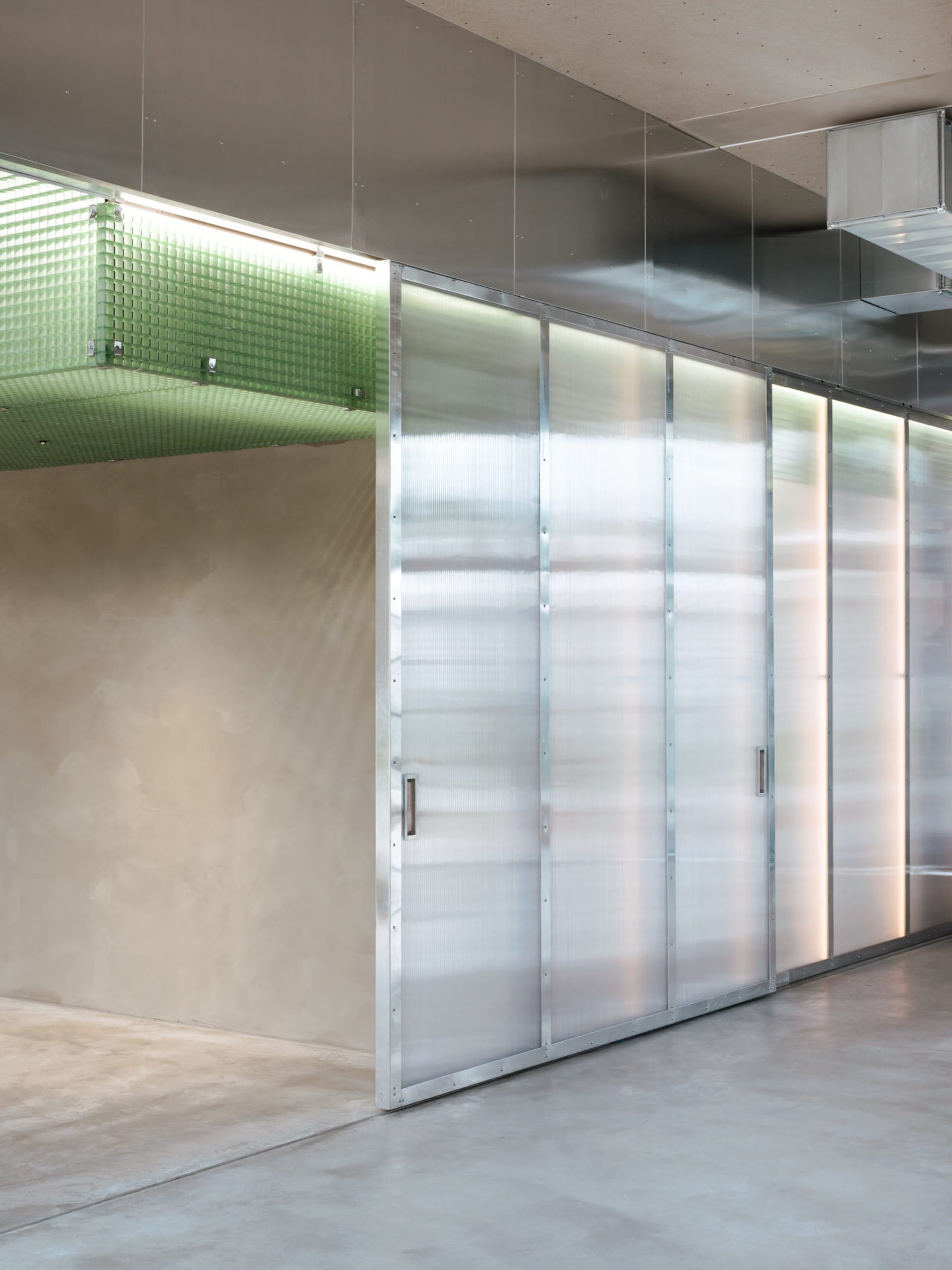 A clean and well-organized hallway with metal walls, multiple doors, and a focus on functionality and efficiency