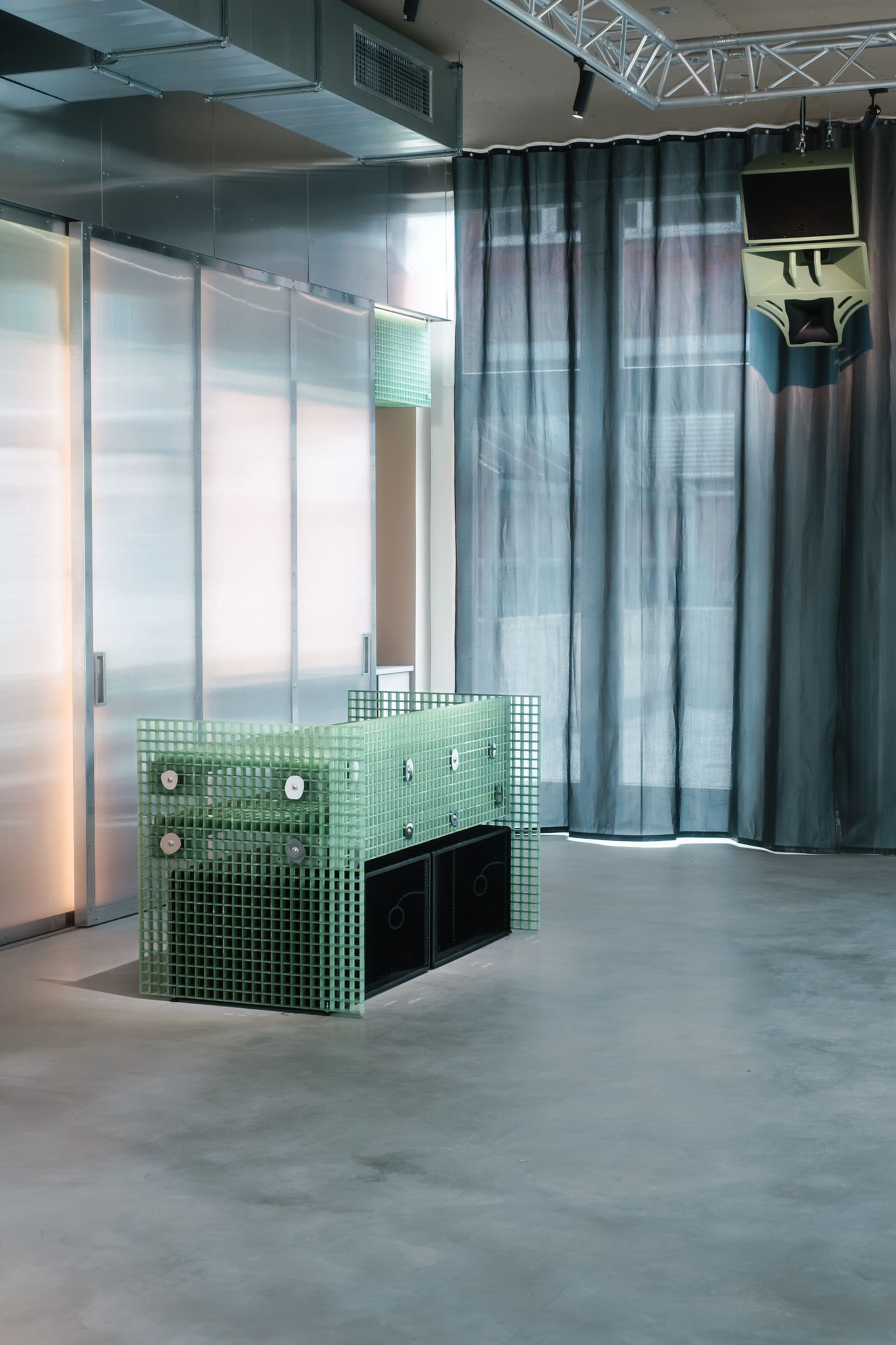 A modern dining space with a unique metal table and two chairs, surrounded by a minimalist atmosphere with a focus on functionality and simplicity
