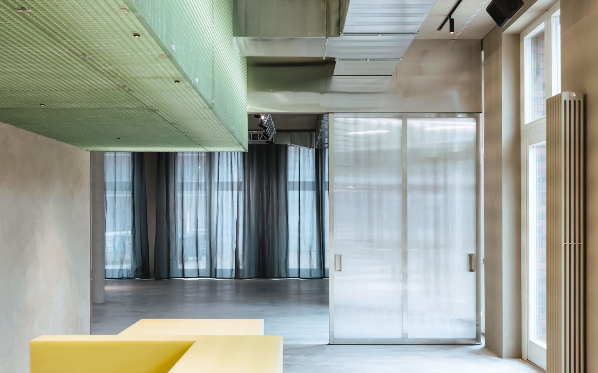 Empty modern room with a glass doorway, a yellow table outside, and natural light