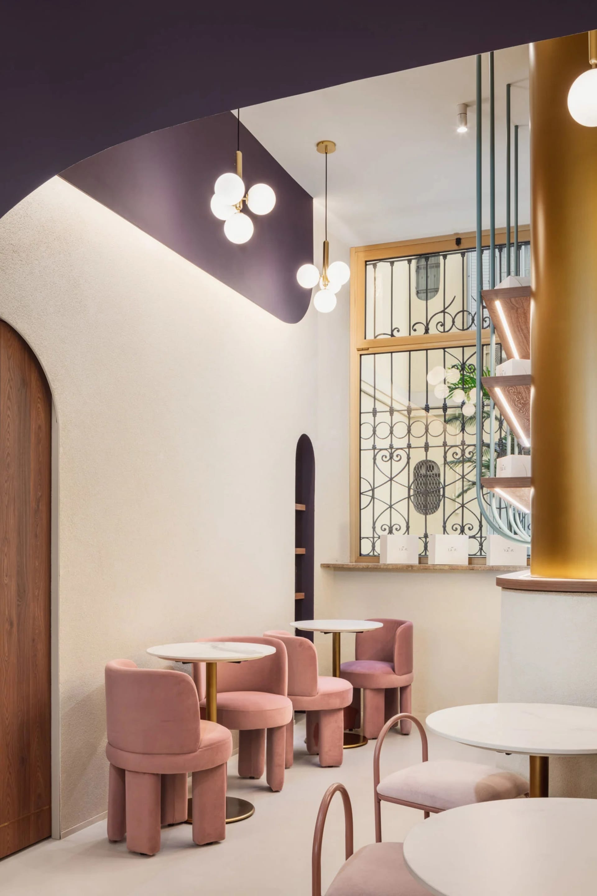 Warm and inviting restaurant interior with pink chairs and tables, well-lit with natural light