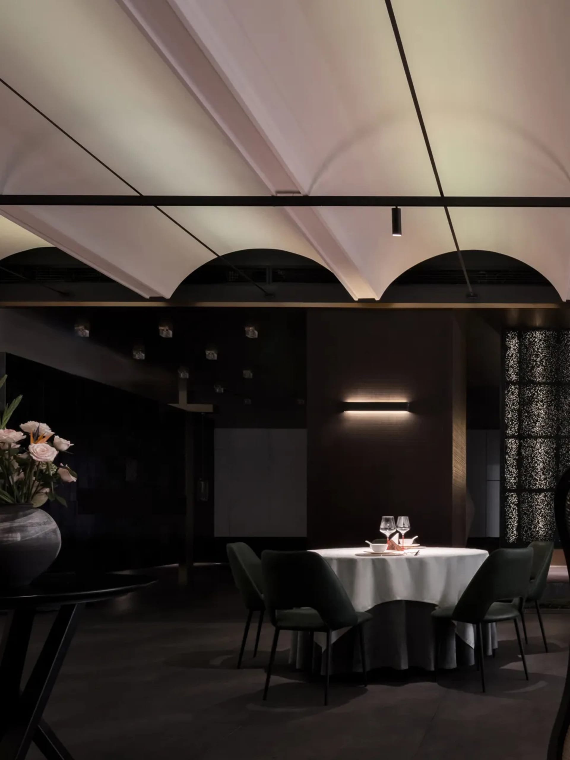 A sophisticated dining area with a table set for a meal, featuring wine glasses, plates, and cutlery, with a well-organized and inviting atmosphere