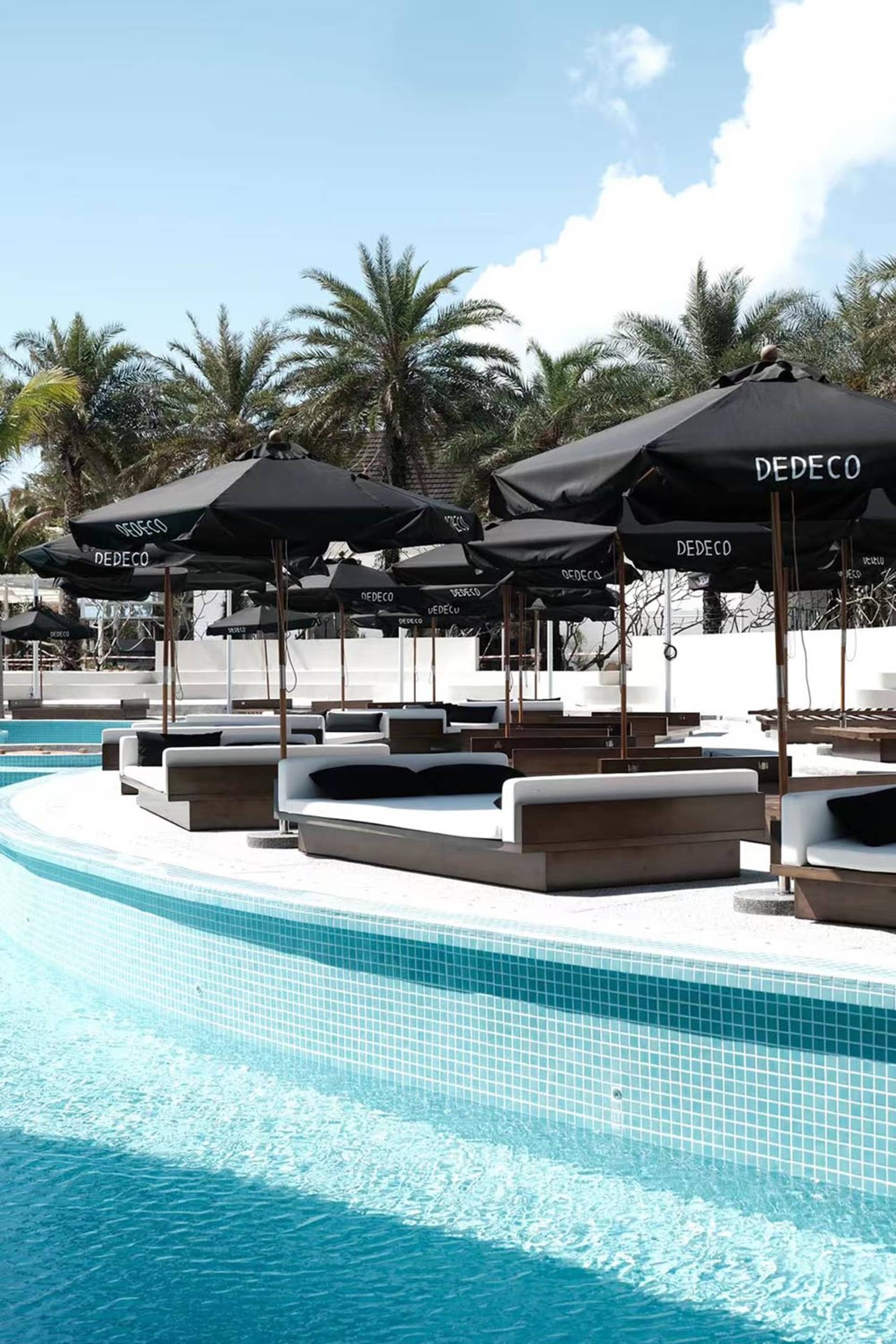 A pool area with lounge chairs, umbrellas, and a comfortable atmosphere for relaxation