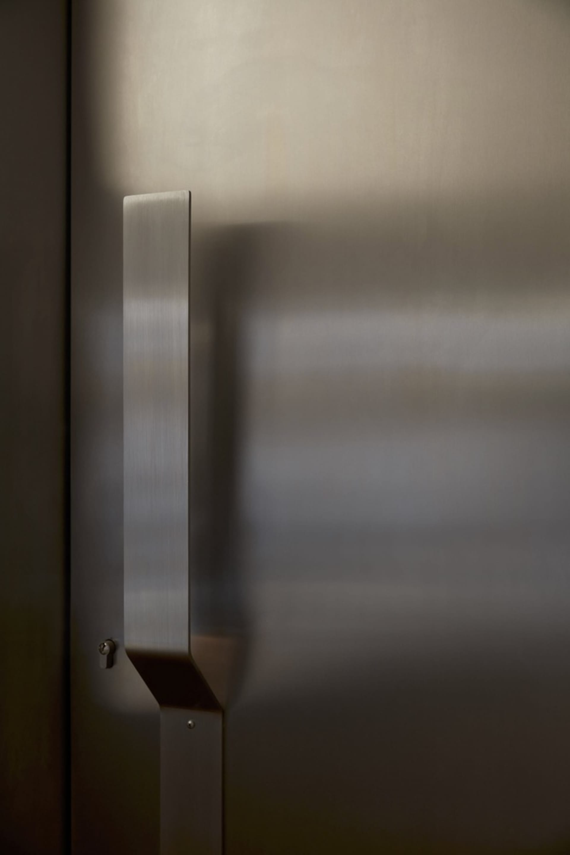 A doorway with a stainless steel door and metal frame, leading into a hallway with a sense of depth and dimension