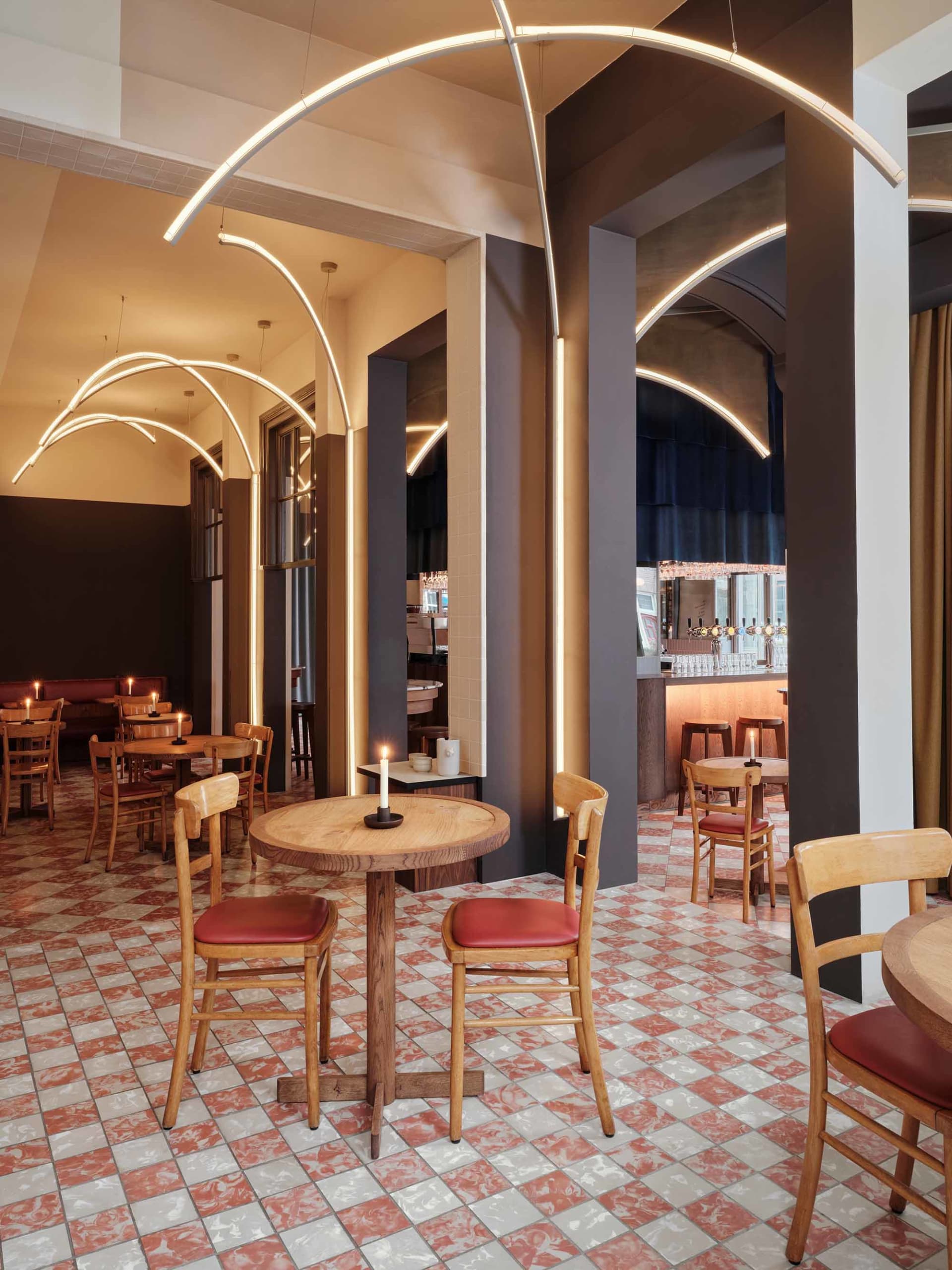 cozy restaurant interior with wooden floors, tables, chairs, and wine glasses