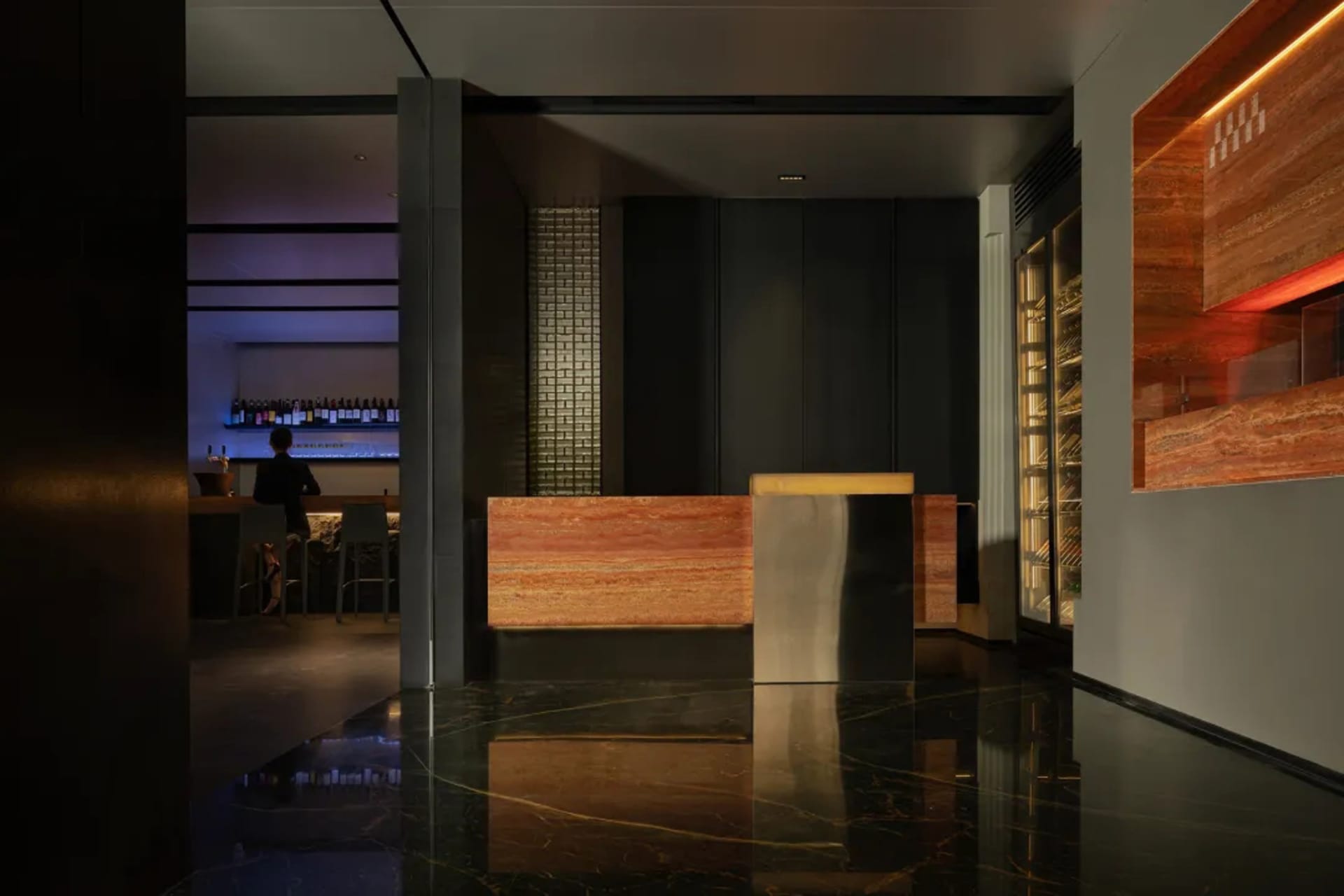 A bar area with a wooden countertop, wine rack, and comfortable seating for guests in an elegant and inviting atmosphere