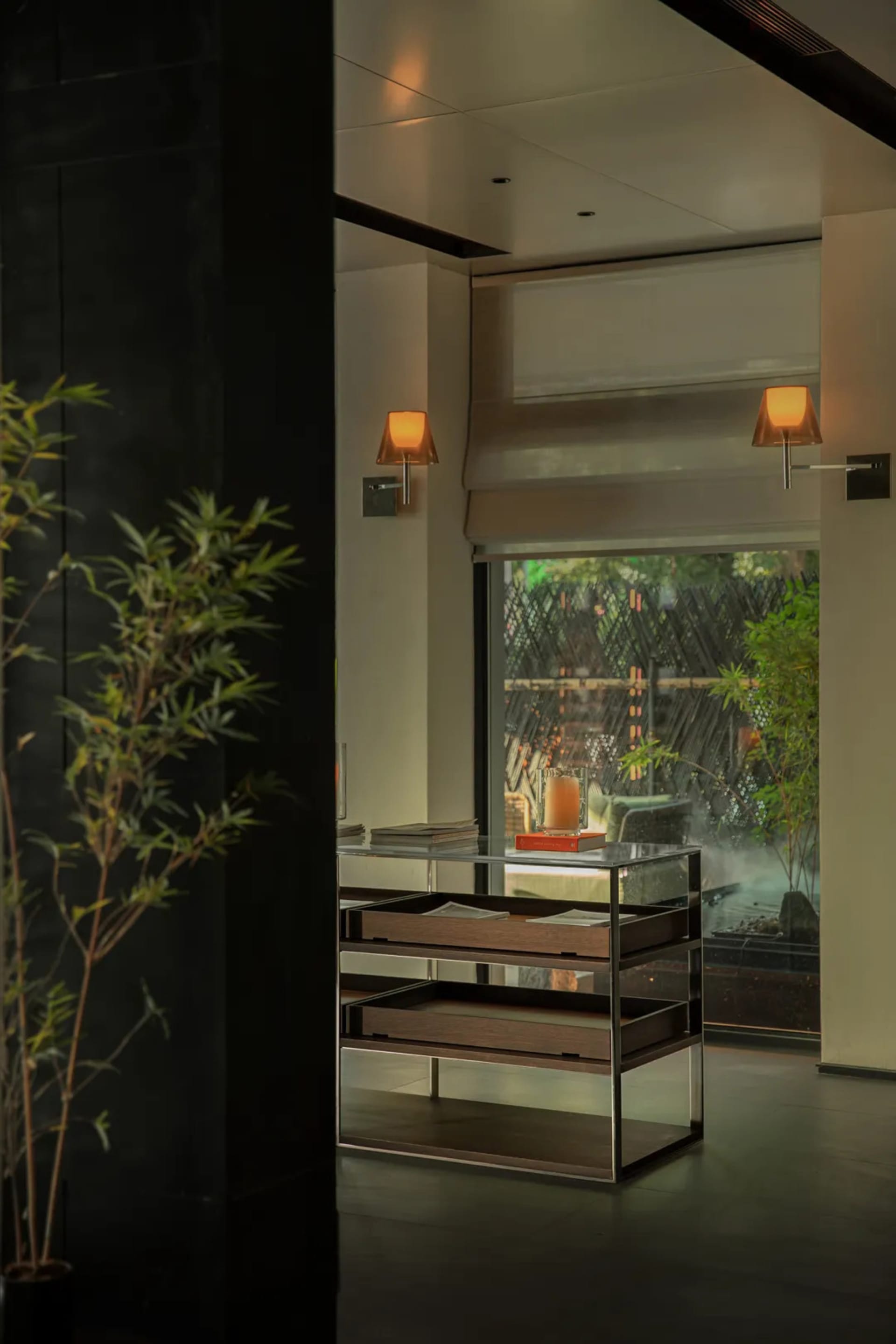 A modern living area with a glass table, two chairs, and a potted plant in the background, featuring a black countertop and a focus on functionality and organization