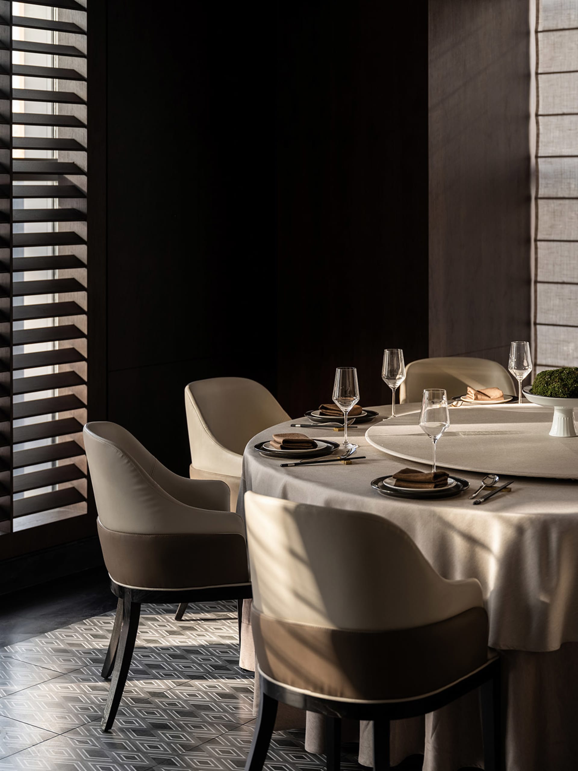 Elegant dining space with a round table, four chairs, and fine dinnerware, set for a formal gathering