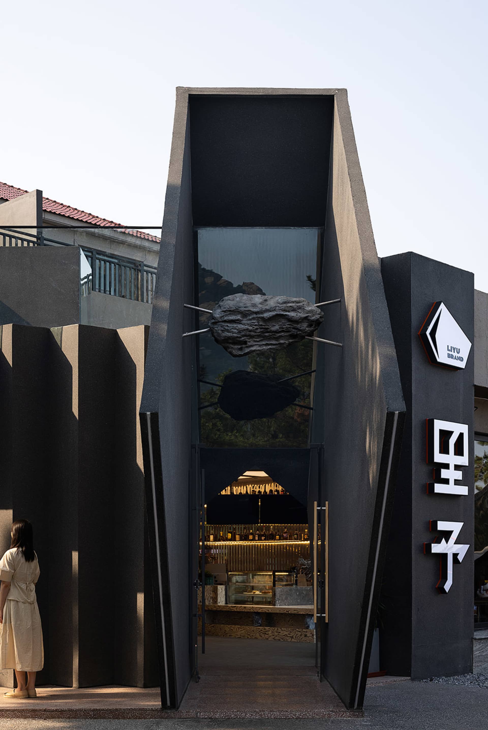 Modern Asian restaurant with a unique rock formation structure, tables, and chairs in a stylish dining space