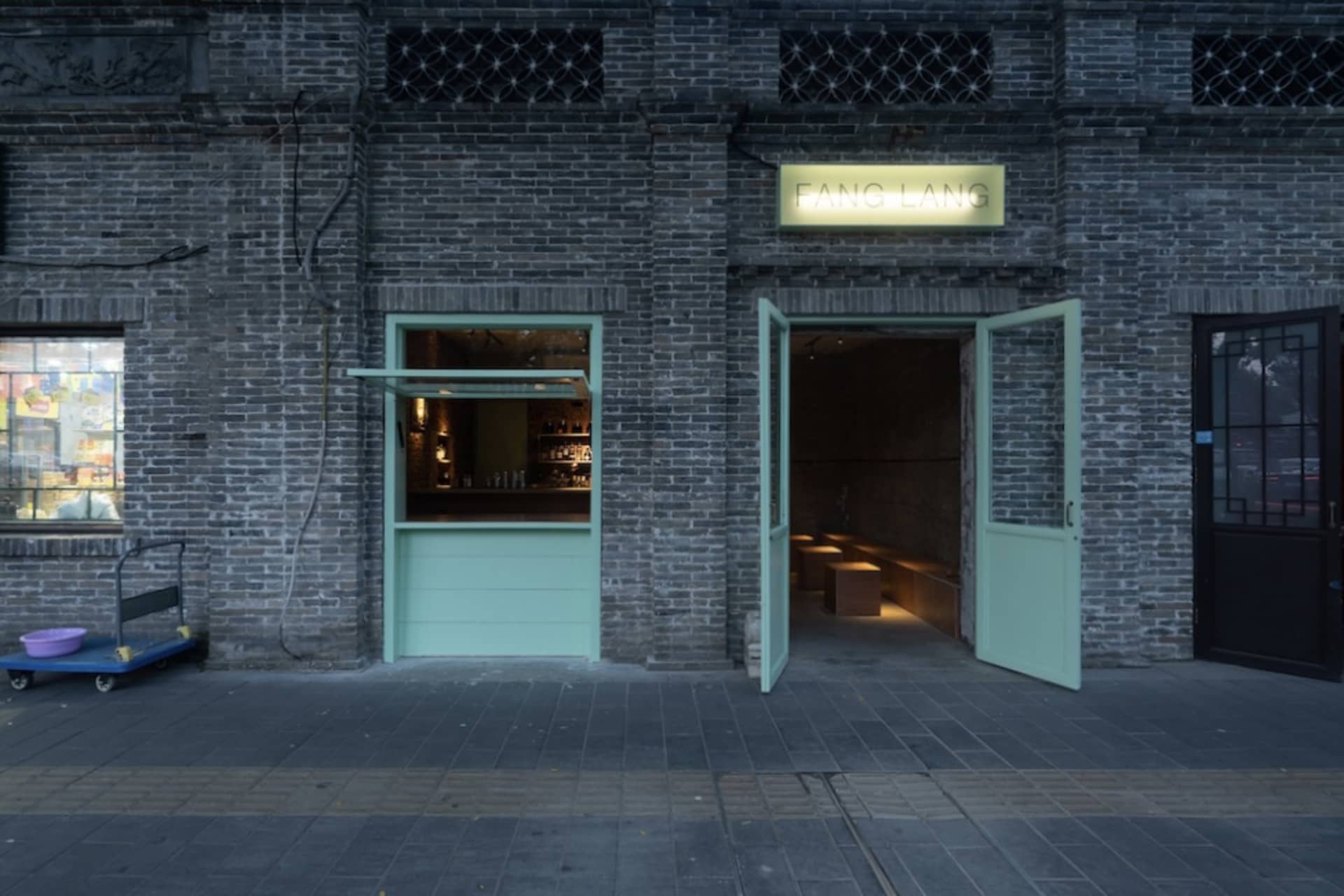 A welcoming bar area with a green door, chairs, and scattered bottles, set in a relaxed atmosphere