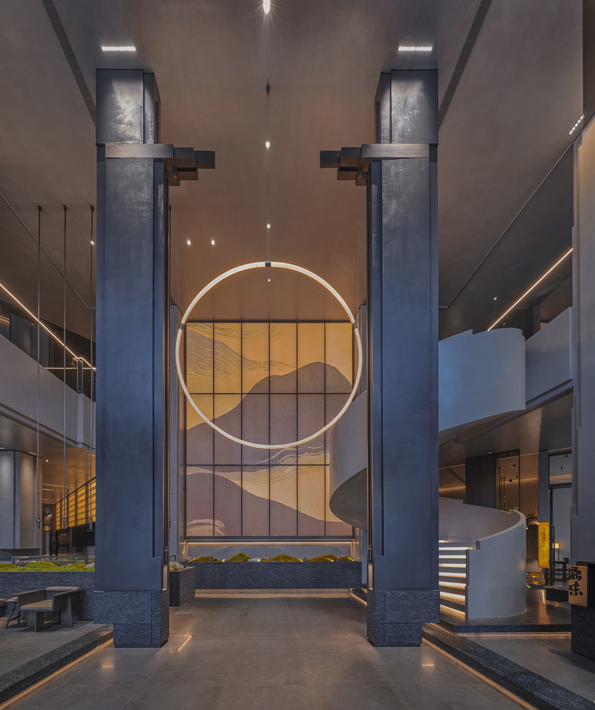 A modern interior space with a circular glass window in front of a staircase, likely made of metal or wood, with a sleek design