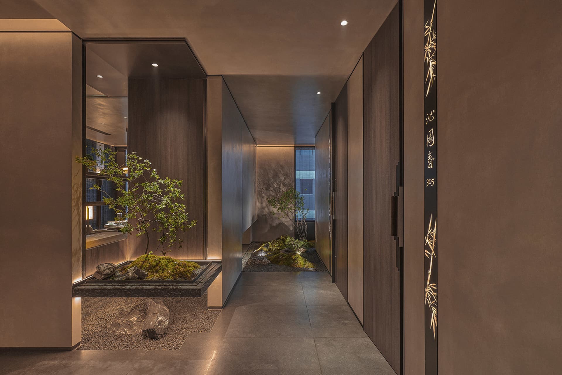 A modern hallway with two doors, one leading to a living area and the other to a dining area, flanked by three potted plants