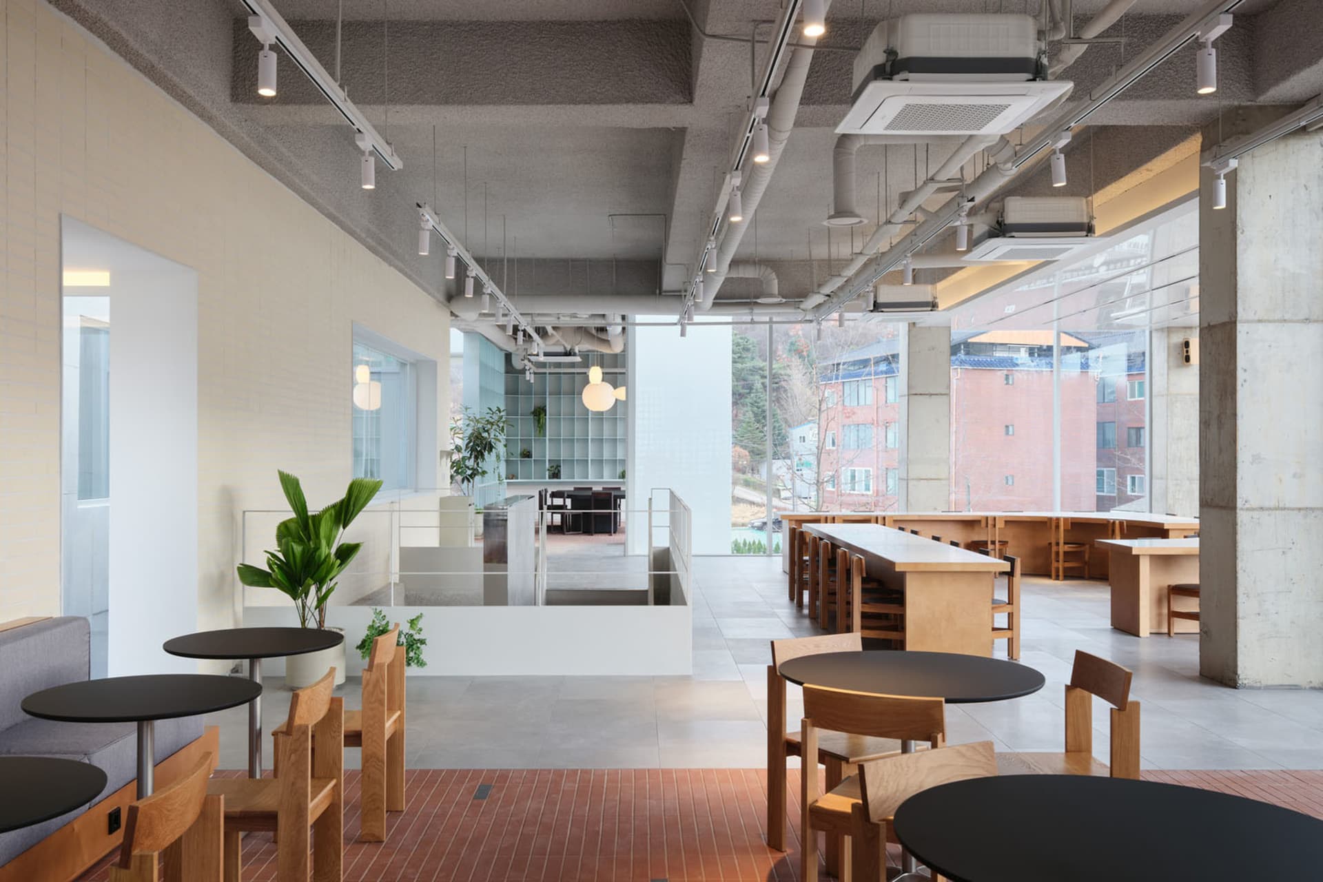 開放式餐廳內部，磁磚地坪、多張桌椅與盆栽
