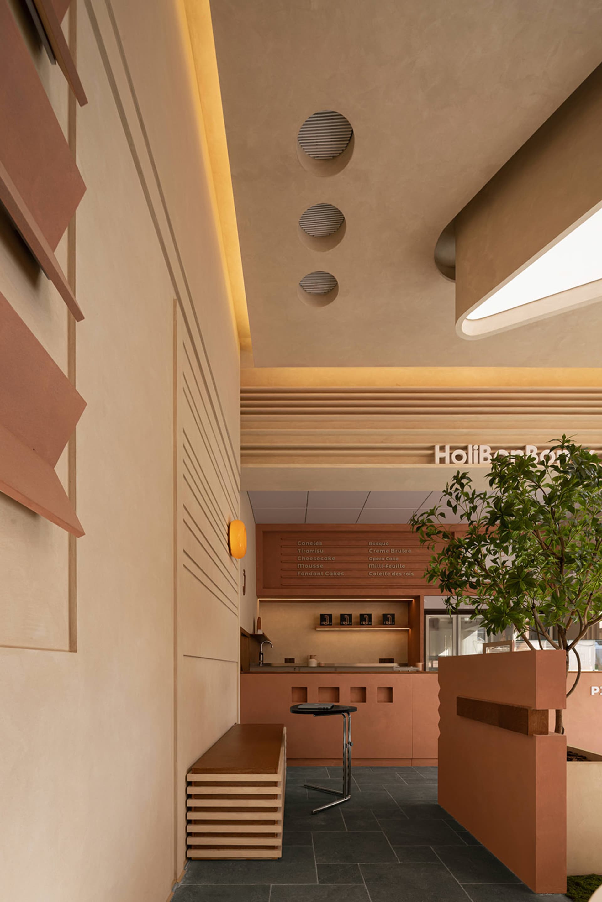 Dining area with beige walls, a table, chairs, and potted plants, in a modern and minimalistic style
