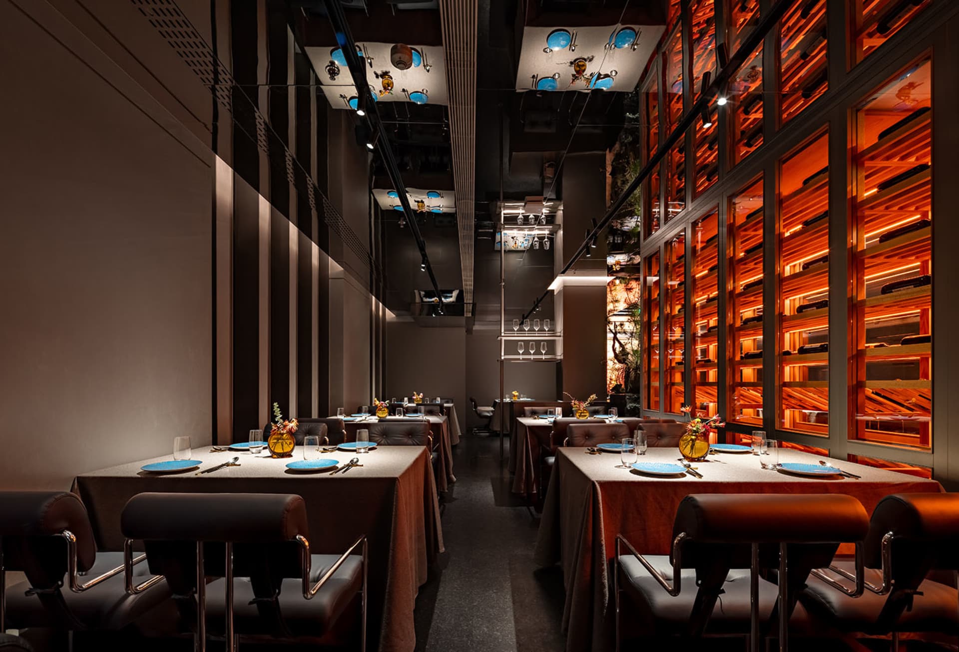 Modern restaurant with dining tables, chairs, and contemporary design elements, featuring warm and inviting lighting