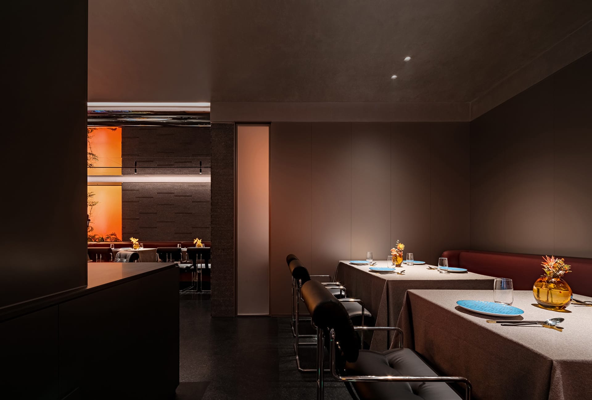 A modern restaurant dining area with tables, chairs, and wine glasses, set up for guests to enjoy their meals in a stylish and inviting atmosphere