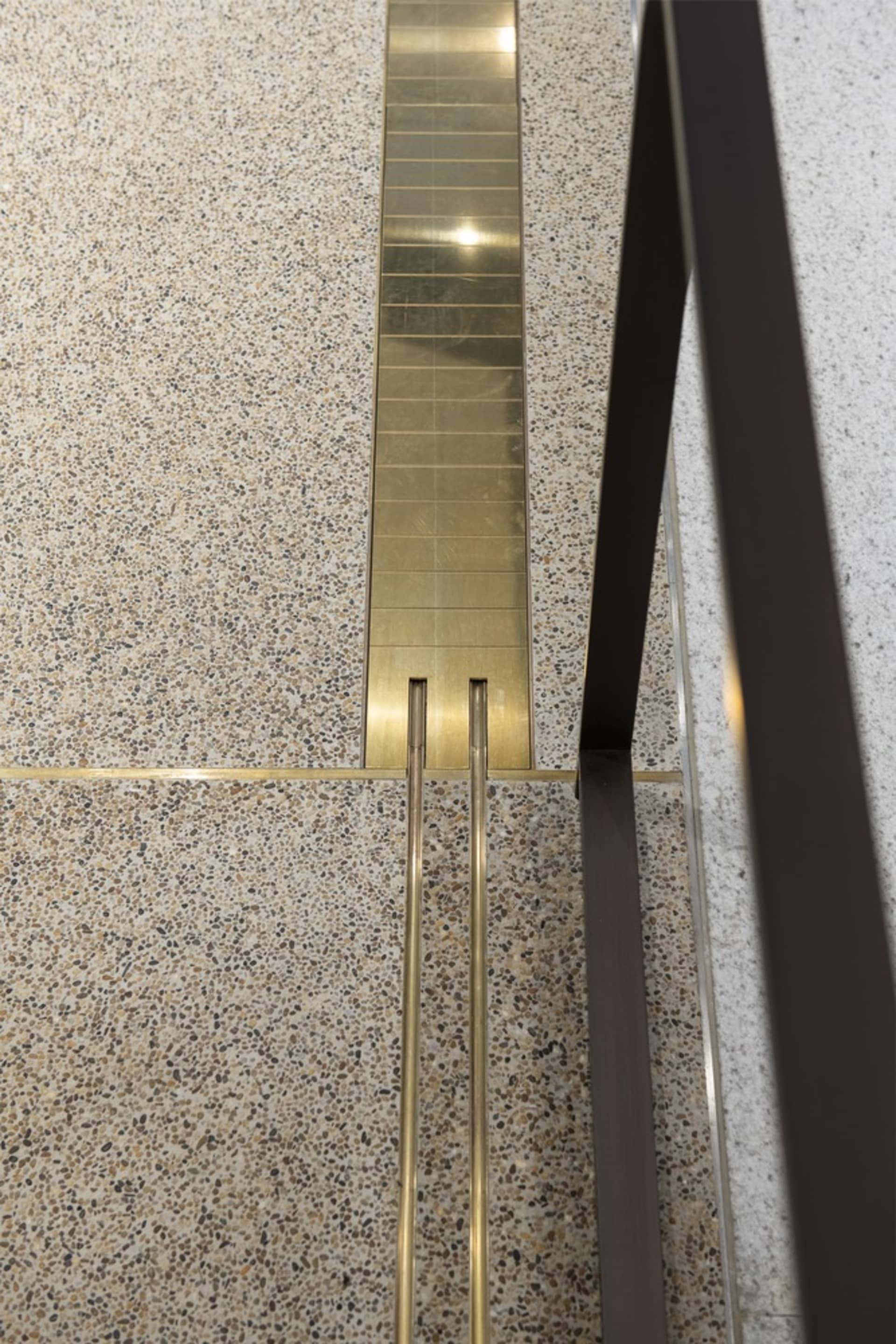 A modern metal staircase in a well-lit interior space with a sense of elegance and sophistication