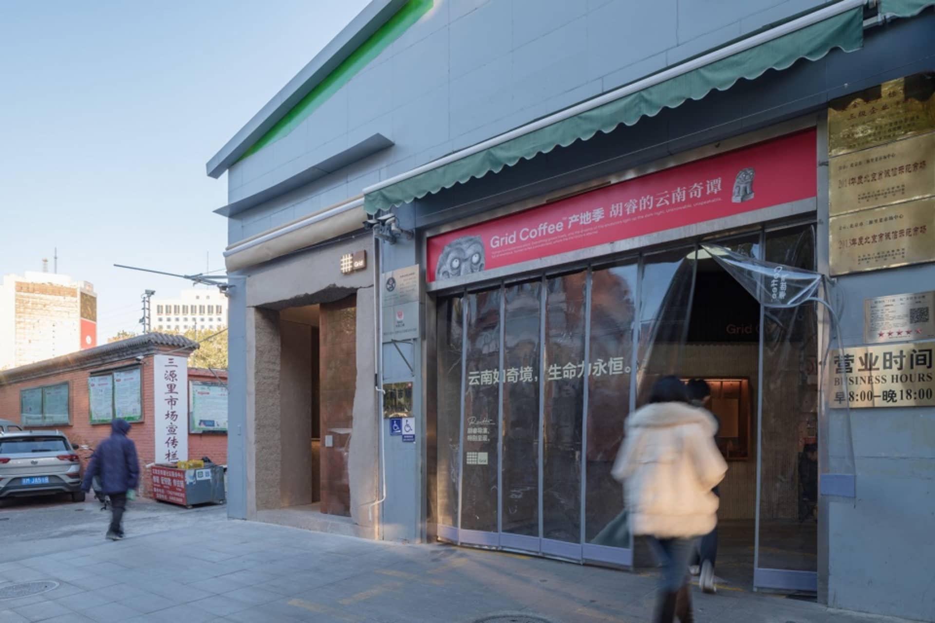 現代咖啡店外觀以灰色為主調，氛圍溫馨誘人，從大片店面玻璃窗清晰可見