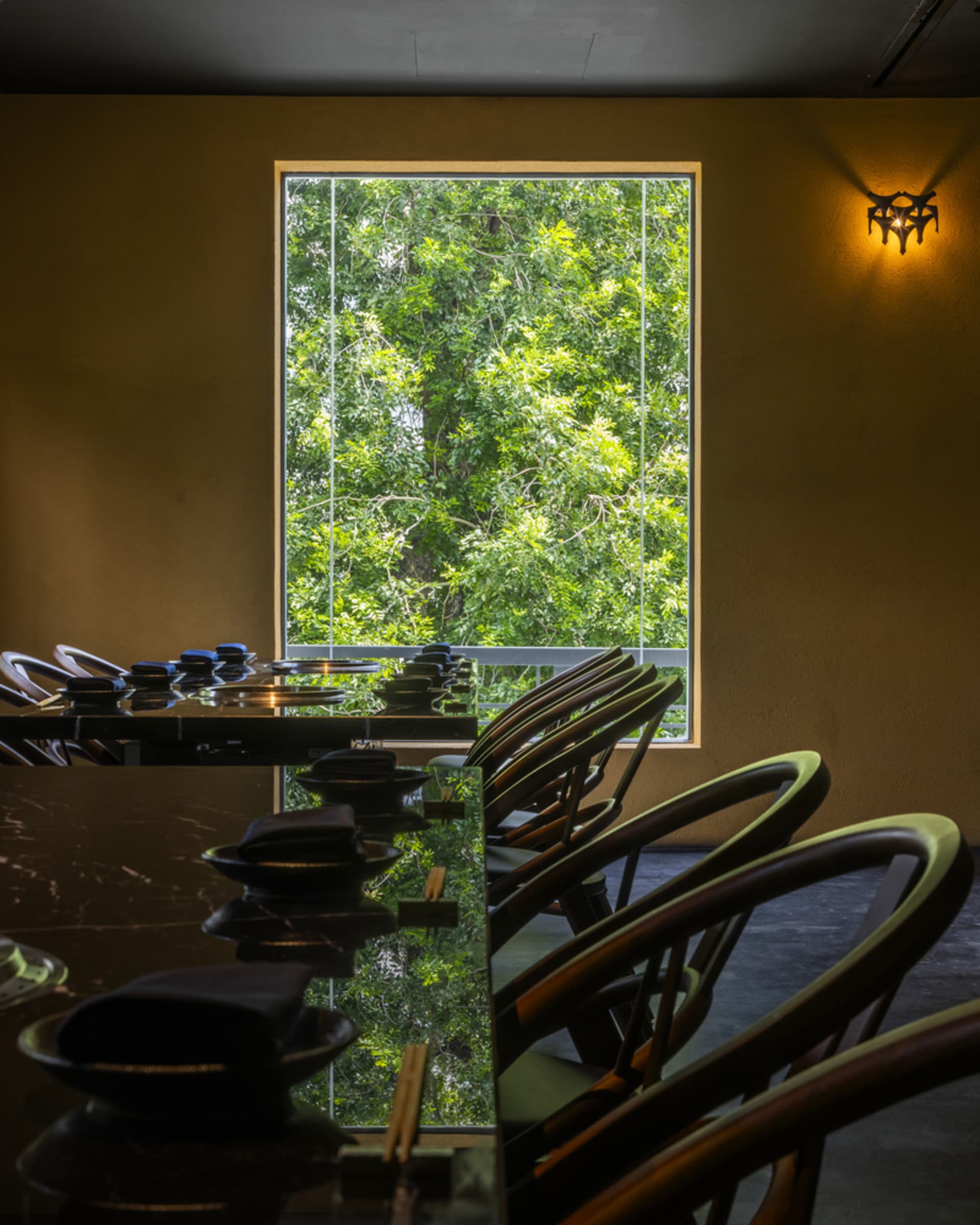 Bright and inviting dining area with a large window, chairs, and a dining table with various items