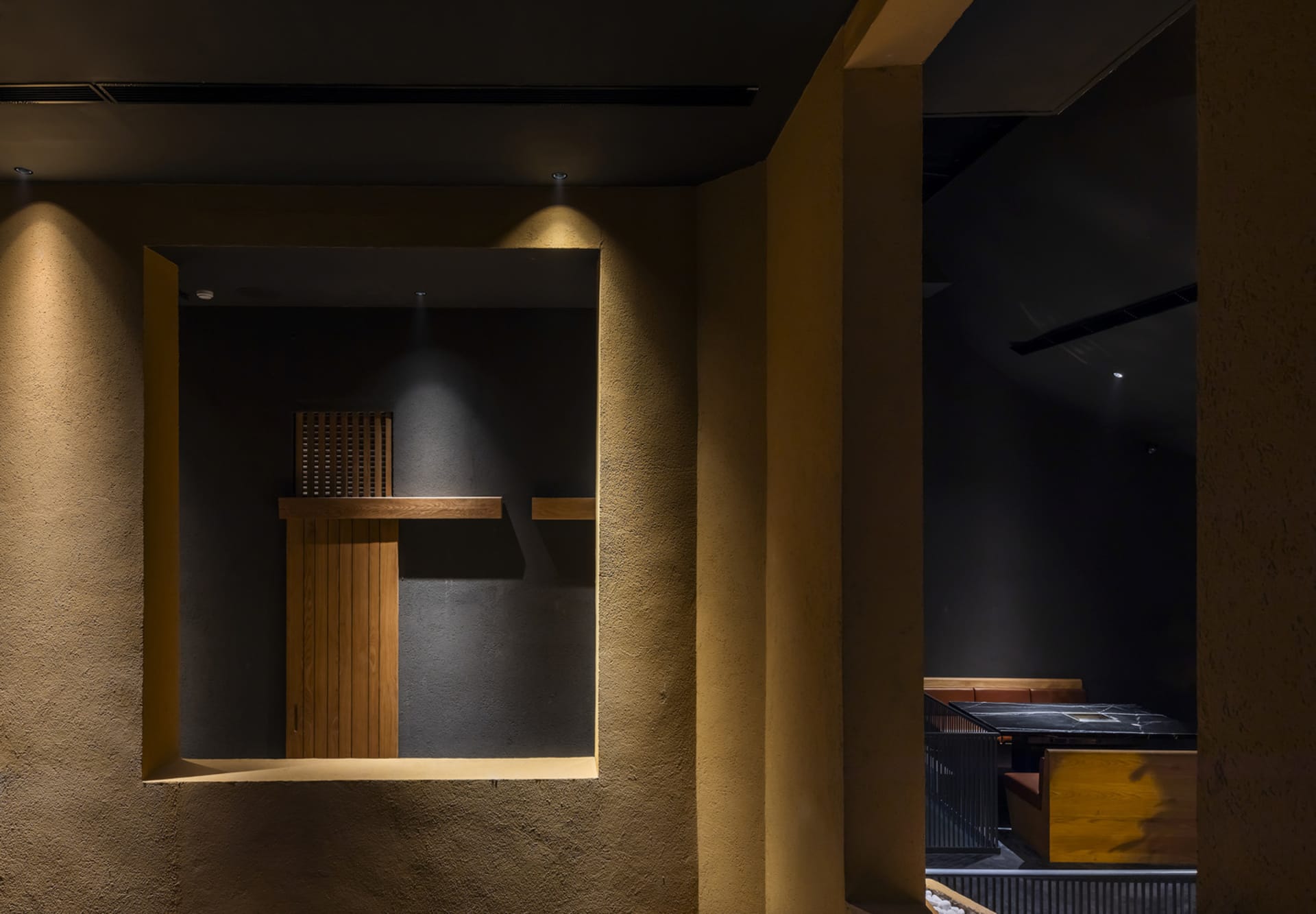 A warm and inviting cafe with brown and yellow walls, wooden benches, and comfortable seating areas, illuminated by soft lighting
