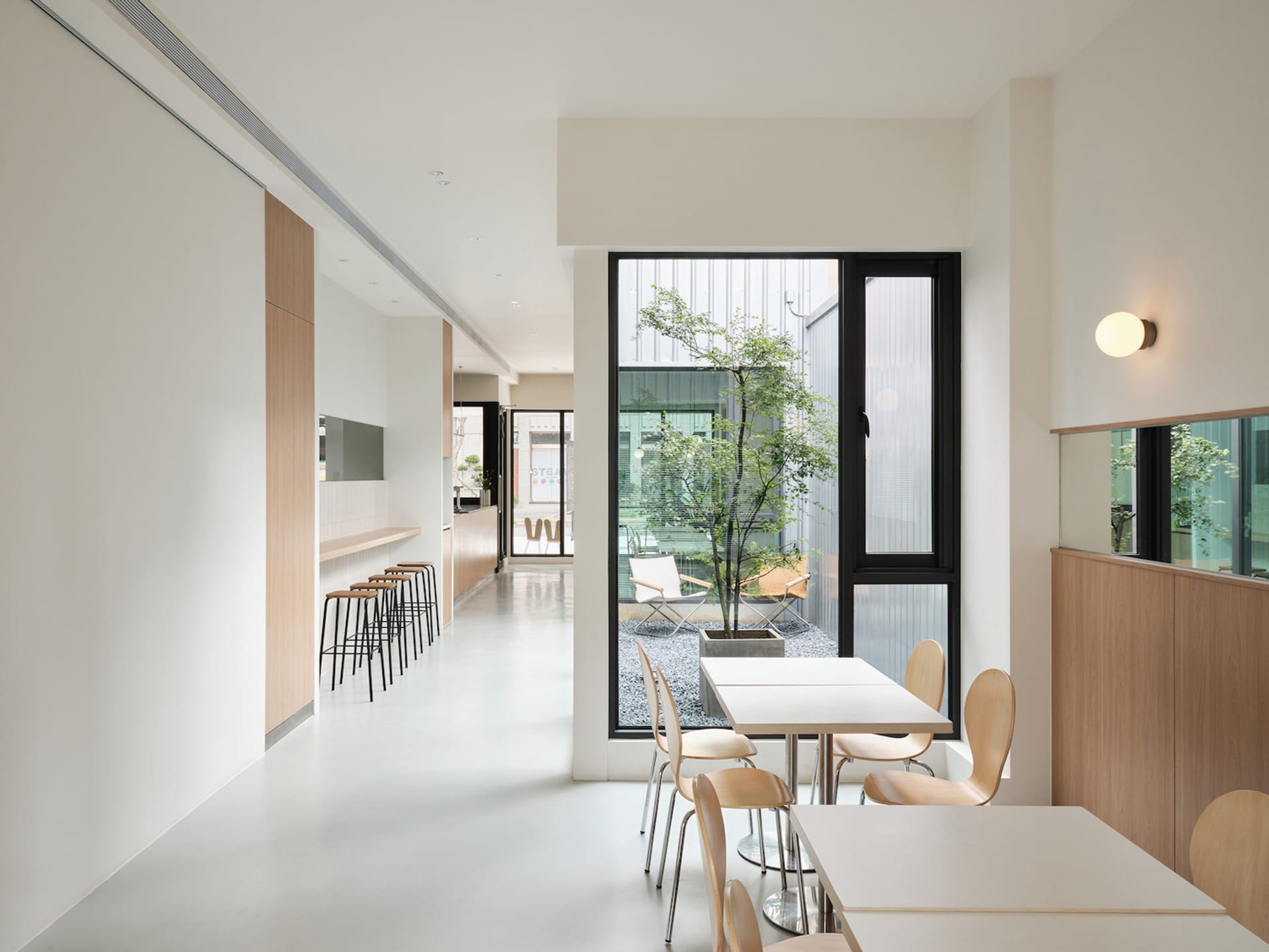 Bright and inviting restaurant interior with multiple tables, chairs, and a mix of wood and metal elements