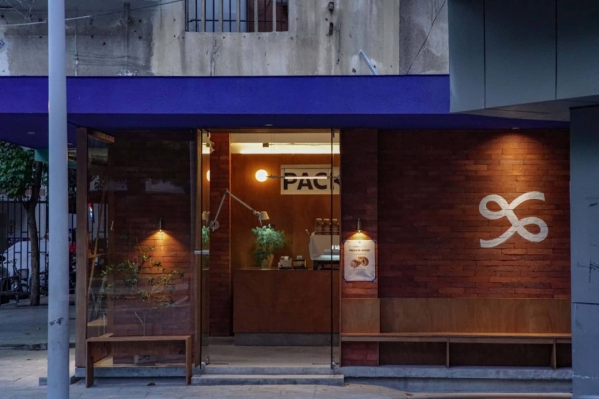 磚牆木椅溫馨咖啡廳內部，搭配餐桌、盆栽、各式杯具與花瓶