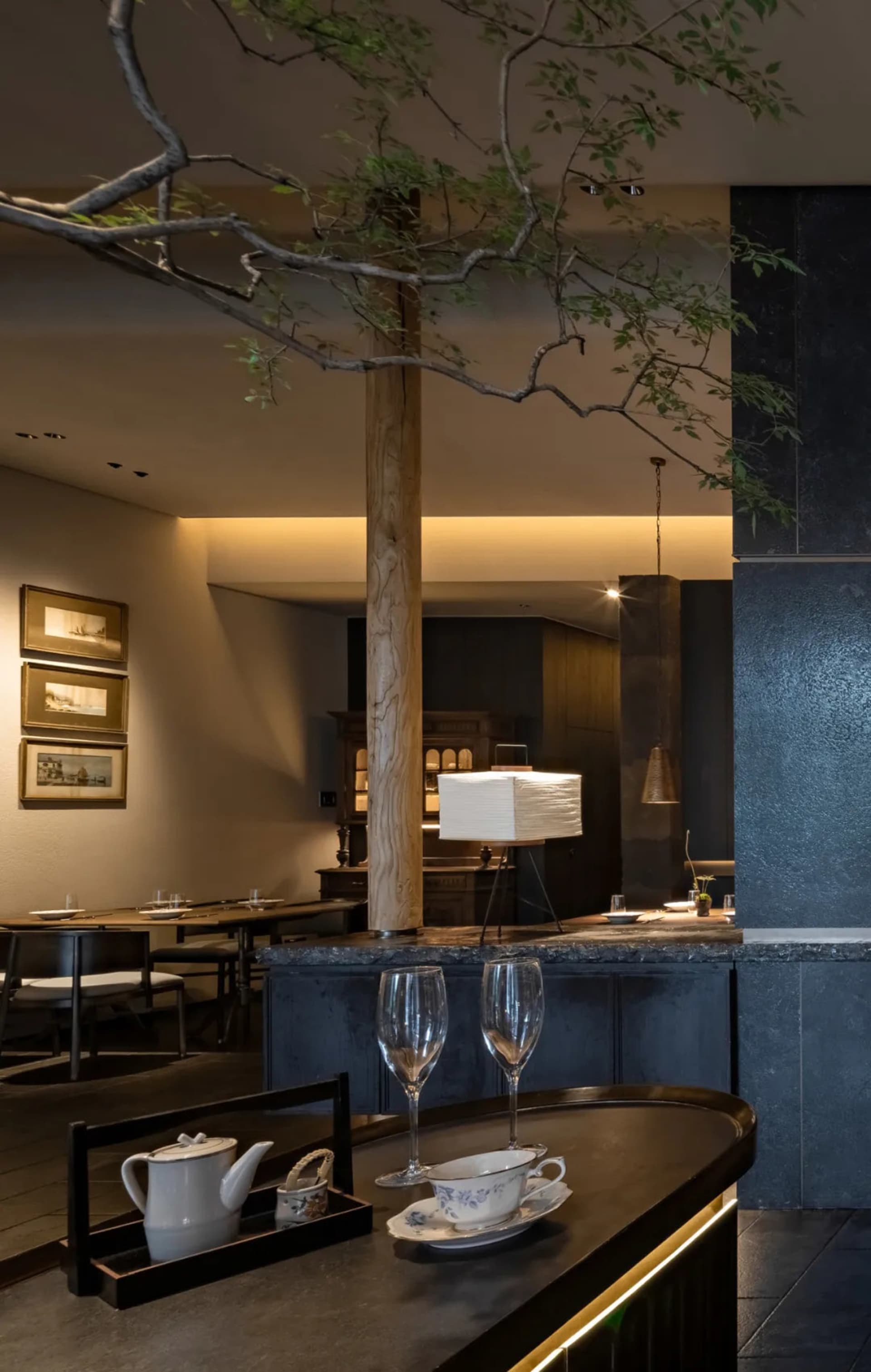 Modern restaurant interior with dining and bar areas, wine glasses, and comfortable seating