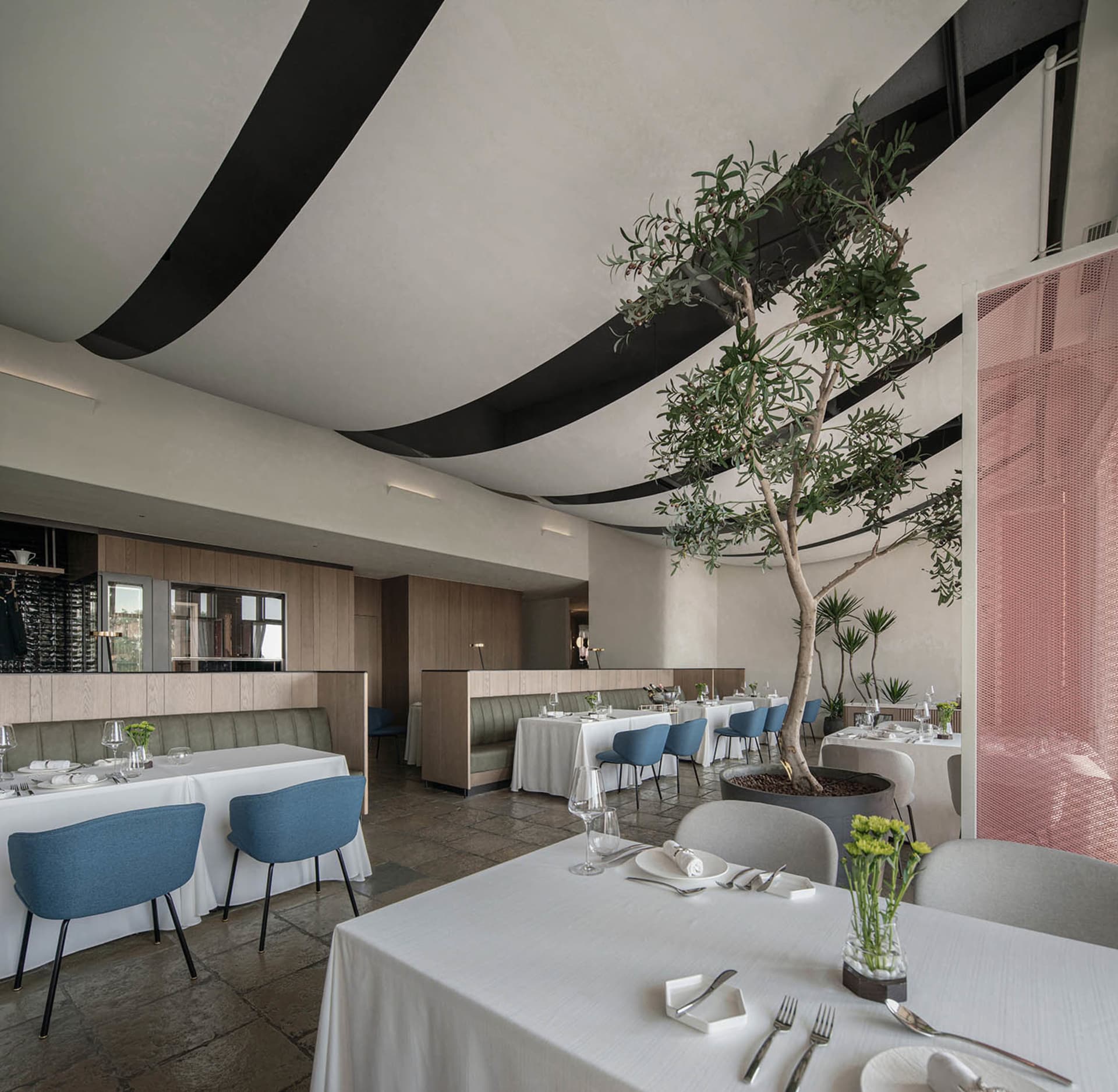 Elegant indoor dining space with a large dining table, multiple chairs, and potted plants