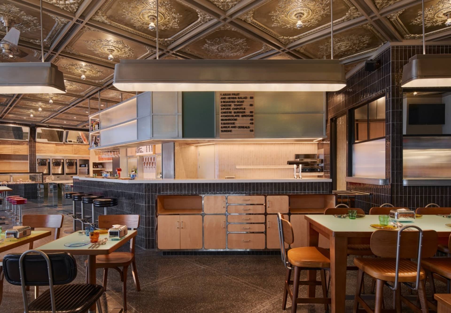 A modern restaurant dining area with a countertop, chairs, and dining tables, featuring a functional and welcoming atmosphere