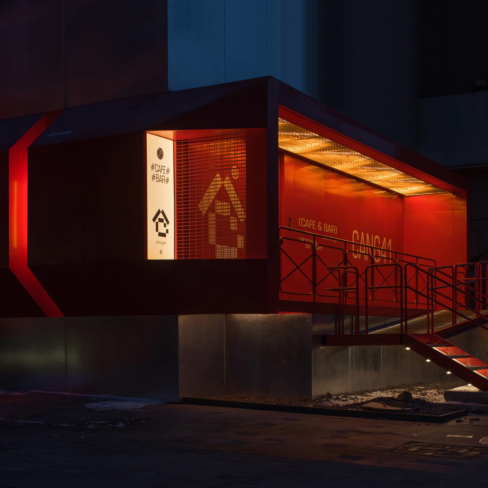 紅色外觀的現代建築，擁有大型窗戶與兩組樓梯，位於當代都市環境中