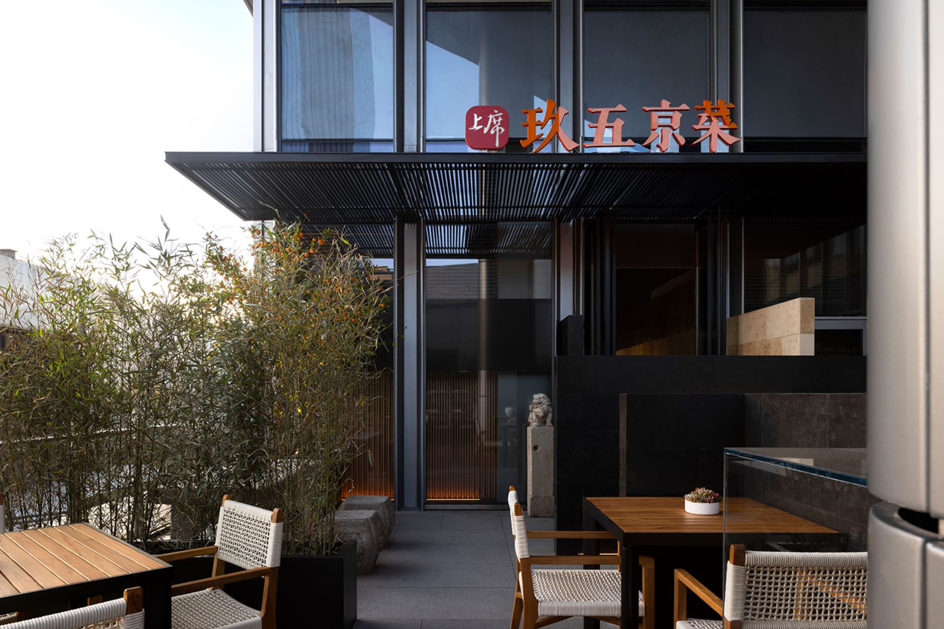 溫馨餐廳室內，設有桌椅、吧台、盆栽與亞洲風格壁飾
