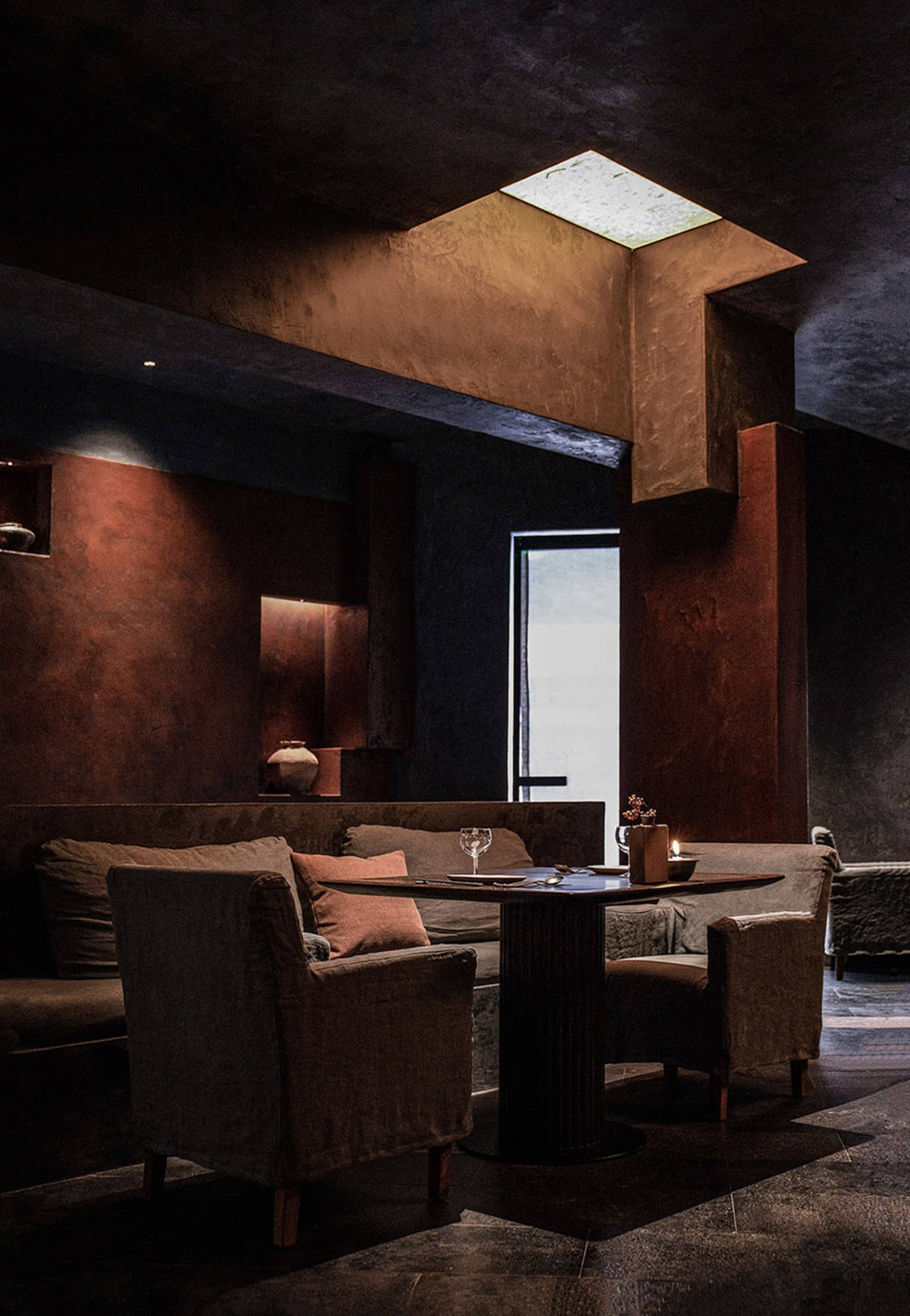 A modern living space with a dining table, two couches, and decorative elements, creating a cozy atmosphere