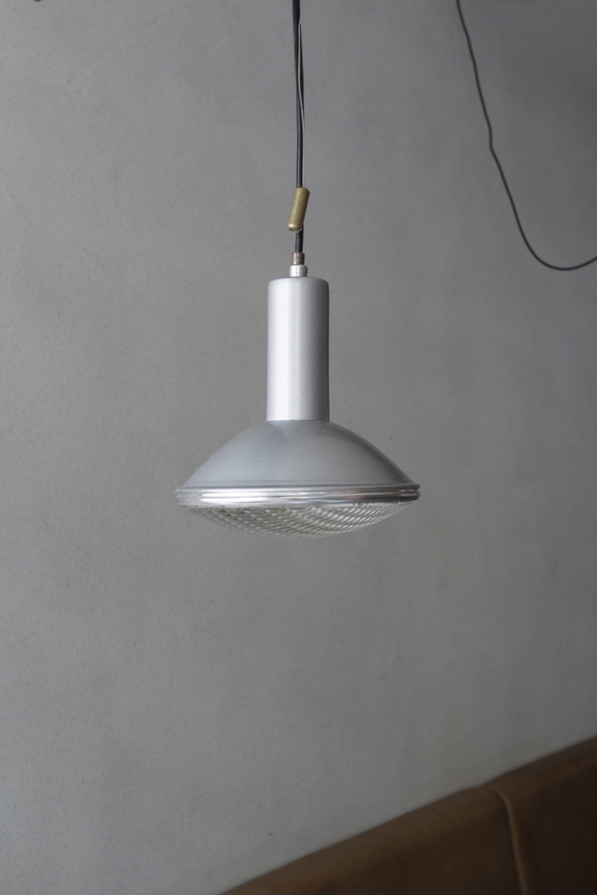 A modern room with a unique lamp hanging from the ceiling, surrounded by clean and minimalistic space with a focus on functionality