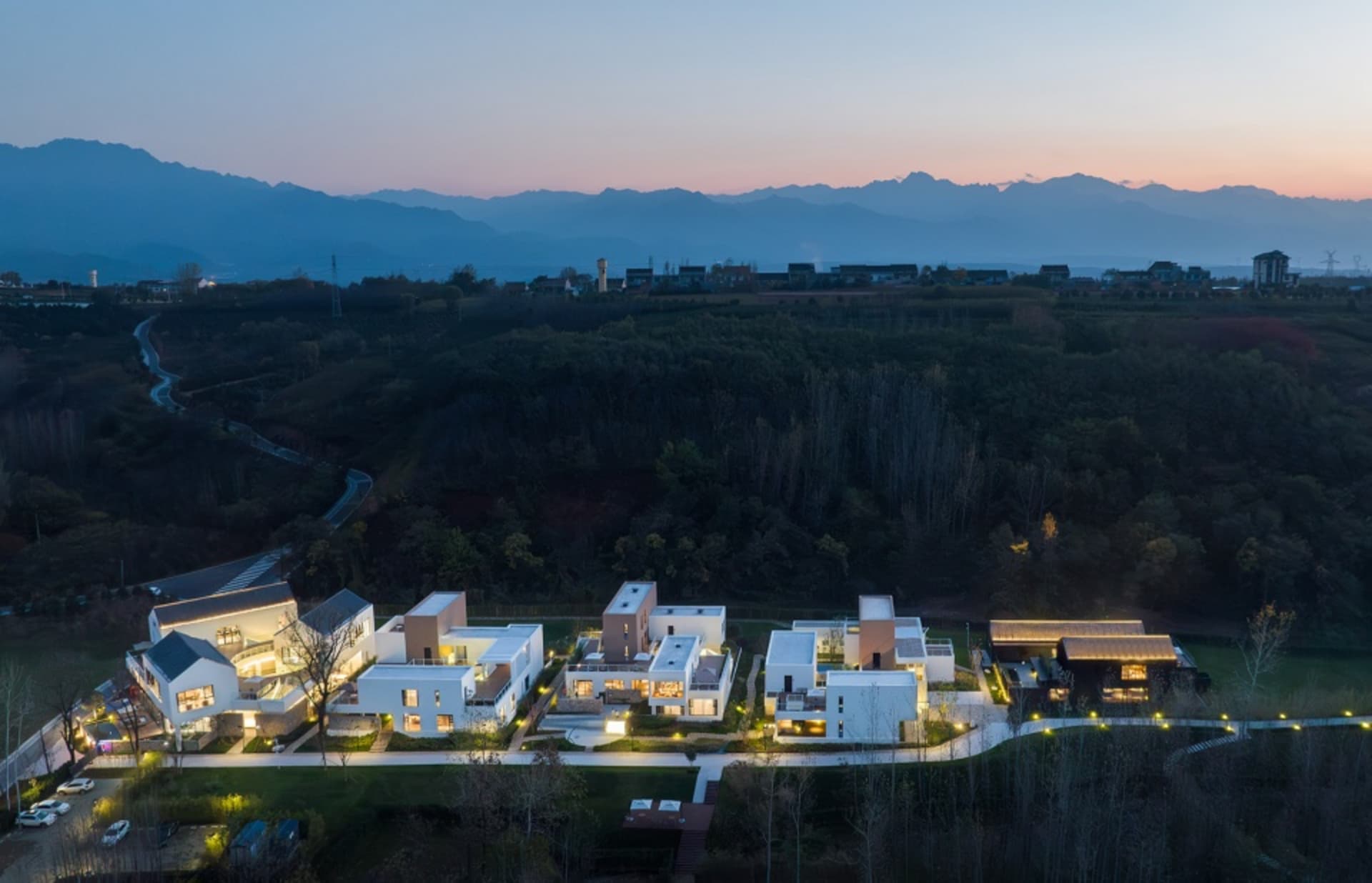 A photo of several modern buildings constructed from stone, blending into the surrounding mountainside with a warm and inviting atmosphere