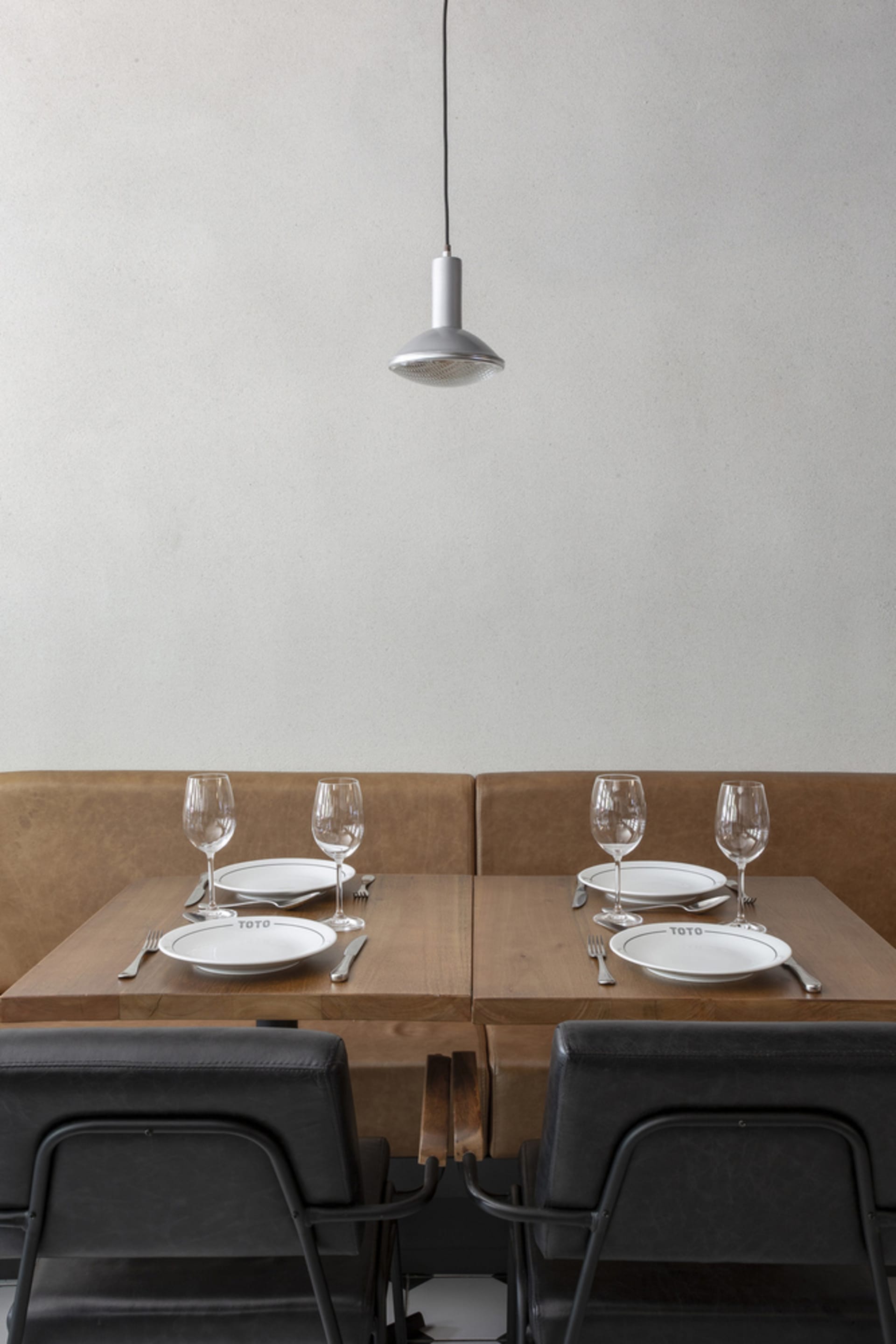 Elegant dining area with brown leather chairs, multiple tables set with wine glasses, plates, and cutlery, creating a sophisticated ambiance