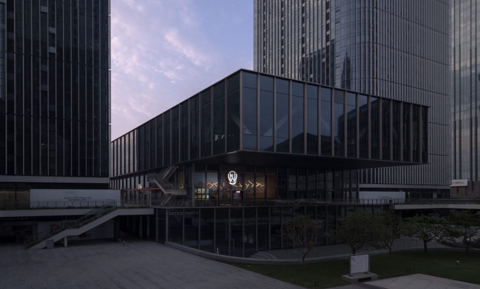 A modern building with a sleek facade featuring glass panels and multiple windows, allowing natural light to enter the interior spaces