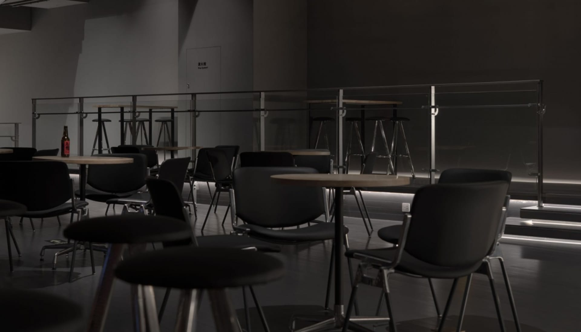 A dark and moody restaurant with several tables and chairs, well-organized and inviting, but empty and lacking natural light