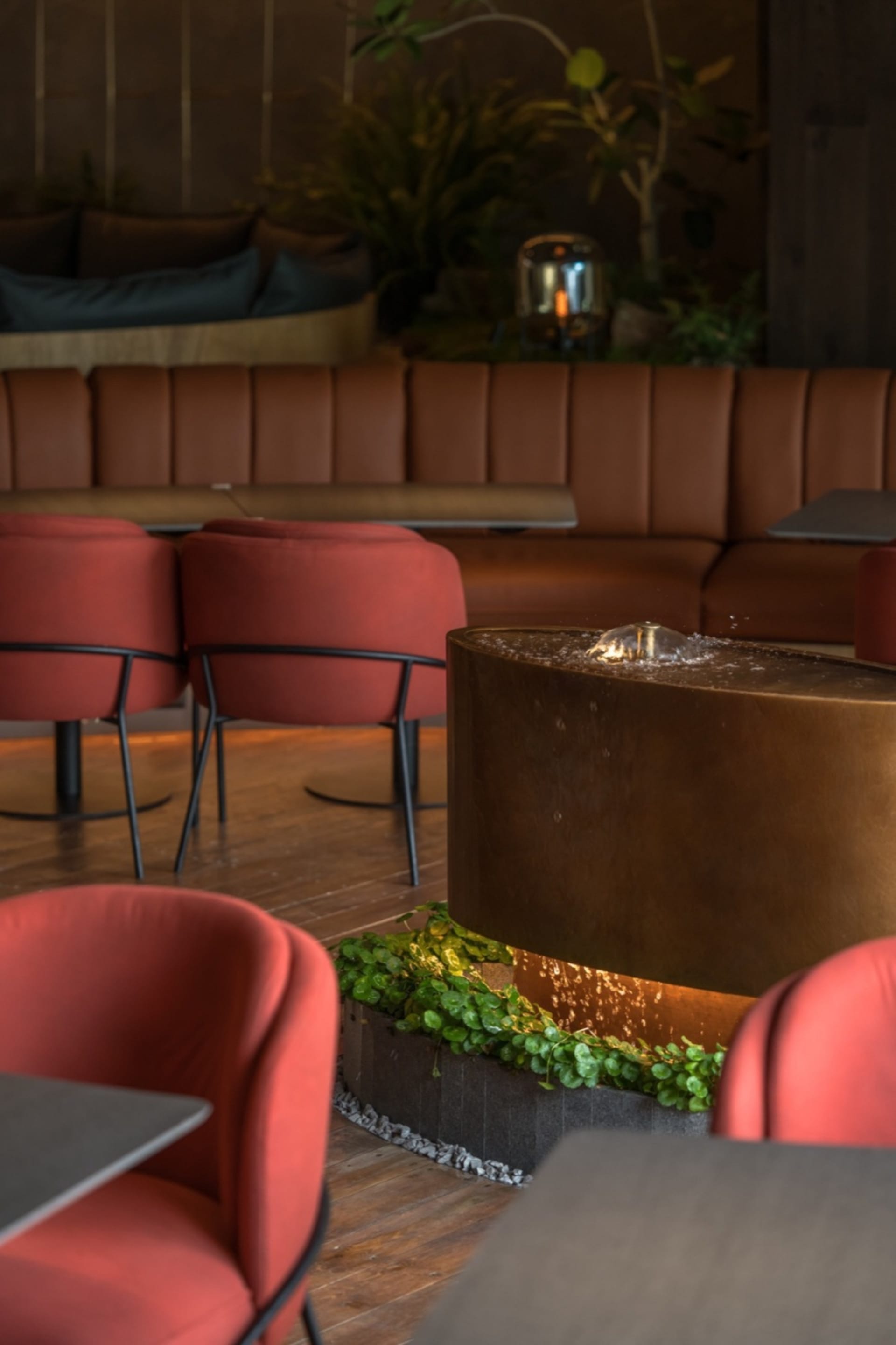 Elegant restaurant dining area with a large bronze fountain, comfortable seating, and inviting atmosphere