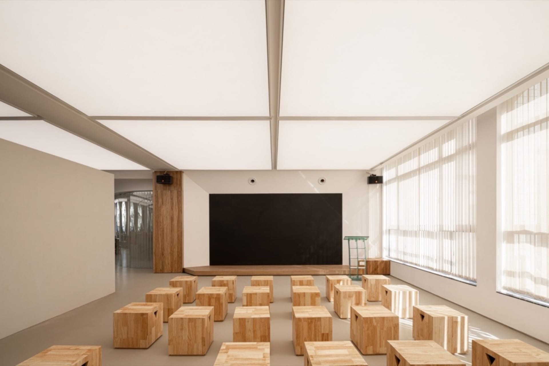 An empty classroom with a blackboard and wooden chairs arranged in rows, creating a sense of organization and calm atmosphere