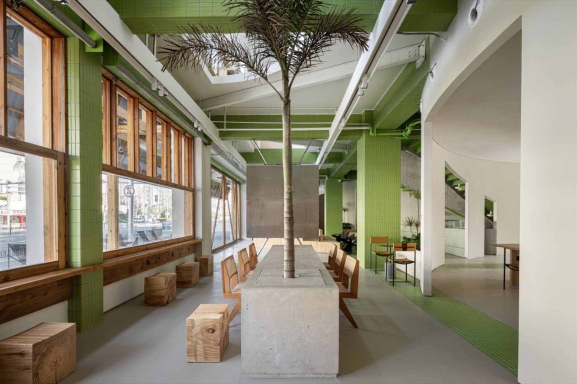 Open modern living space with a concrete island, comfortable seating, and potted plants, featuring a functional and inviting atmosphere
