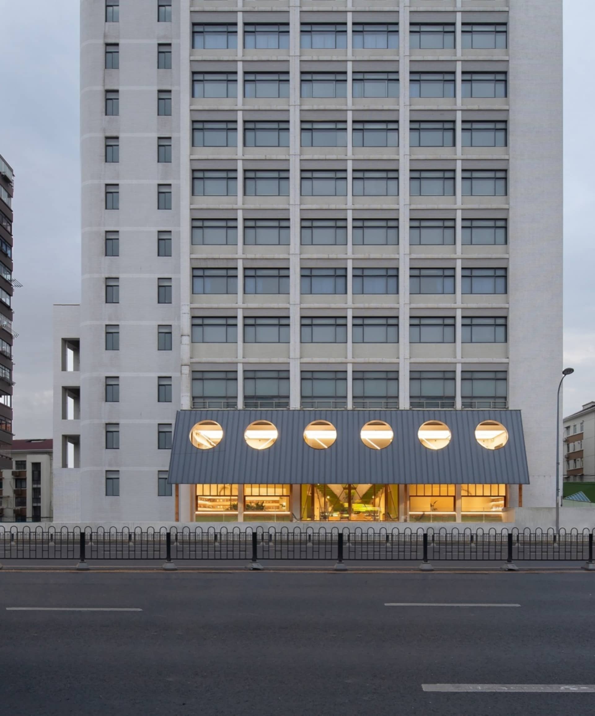 Large modern building with numerous windows, a prominent clock tower, and a sleek design