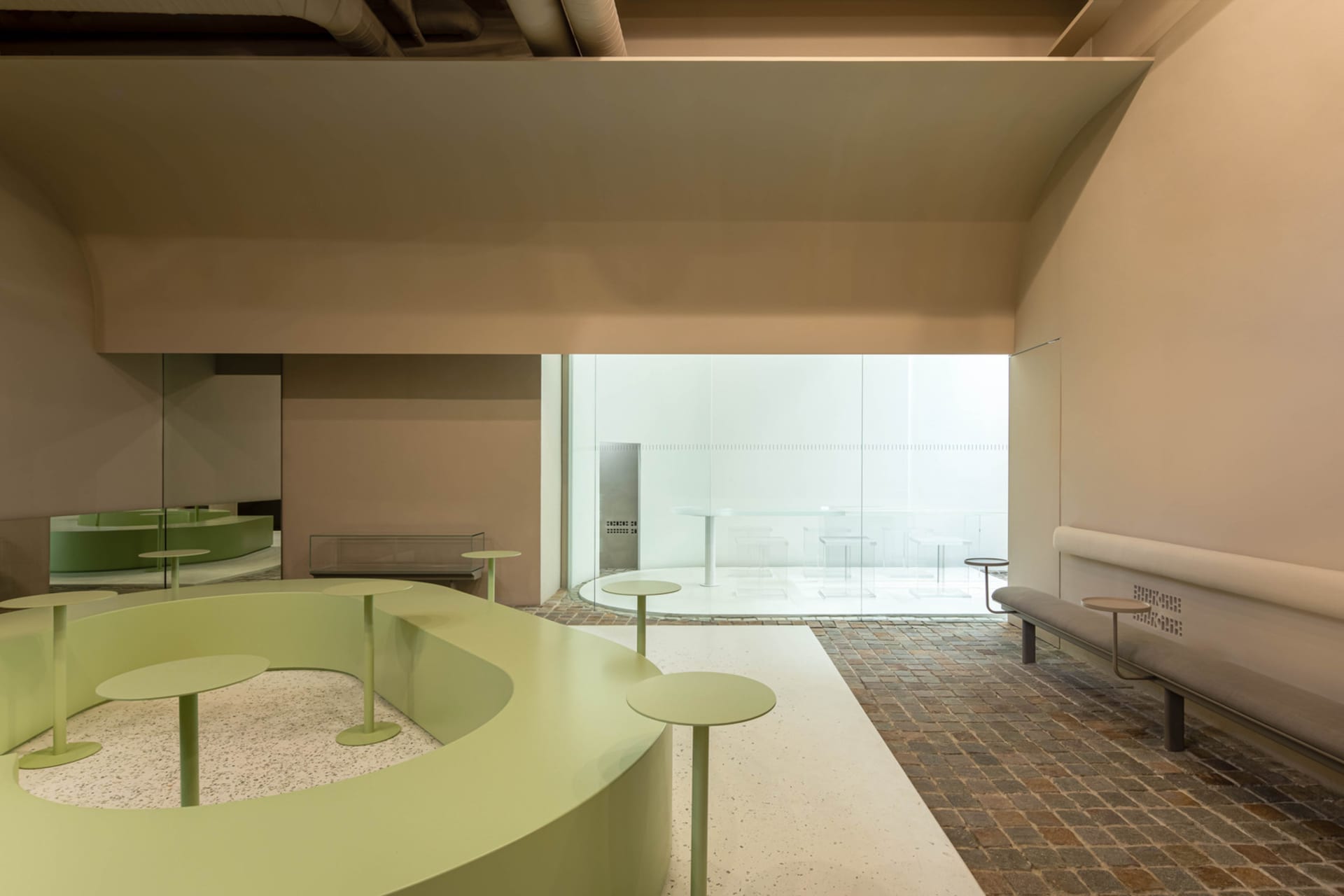 An open space with tables and chairs, circular tables, natural light, and a comfortable atmosphere