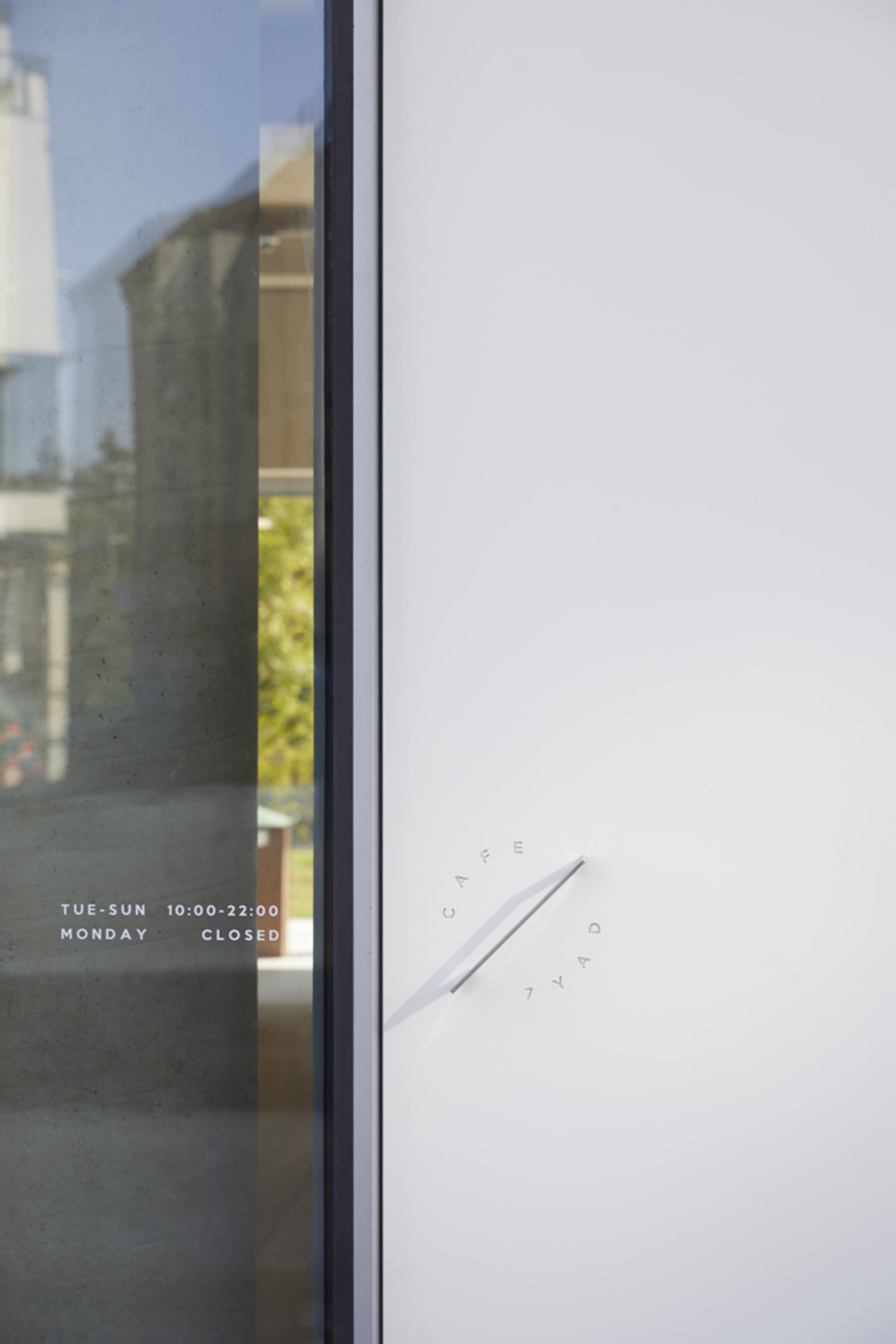 A clean and well-organized hotel lobby entrance with a white door, two clocks, and a sense of modernity