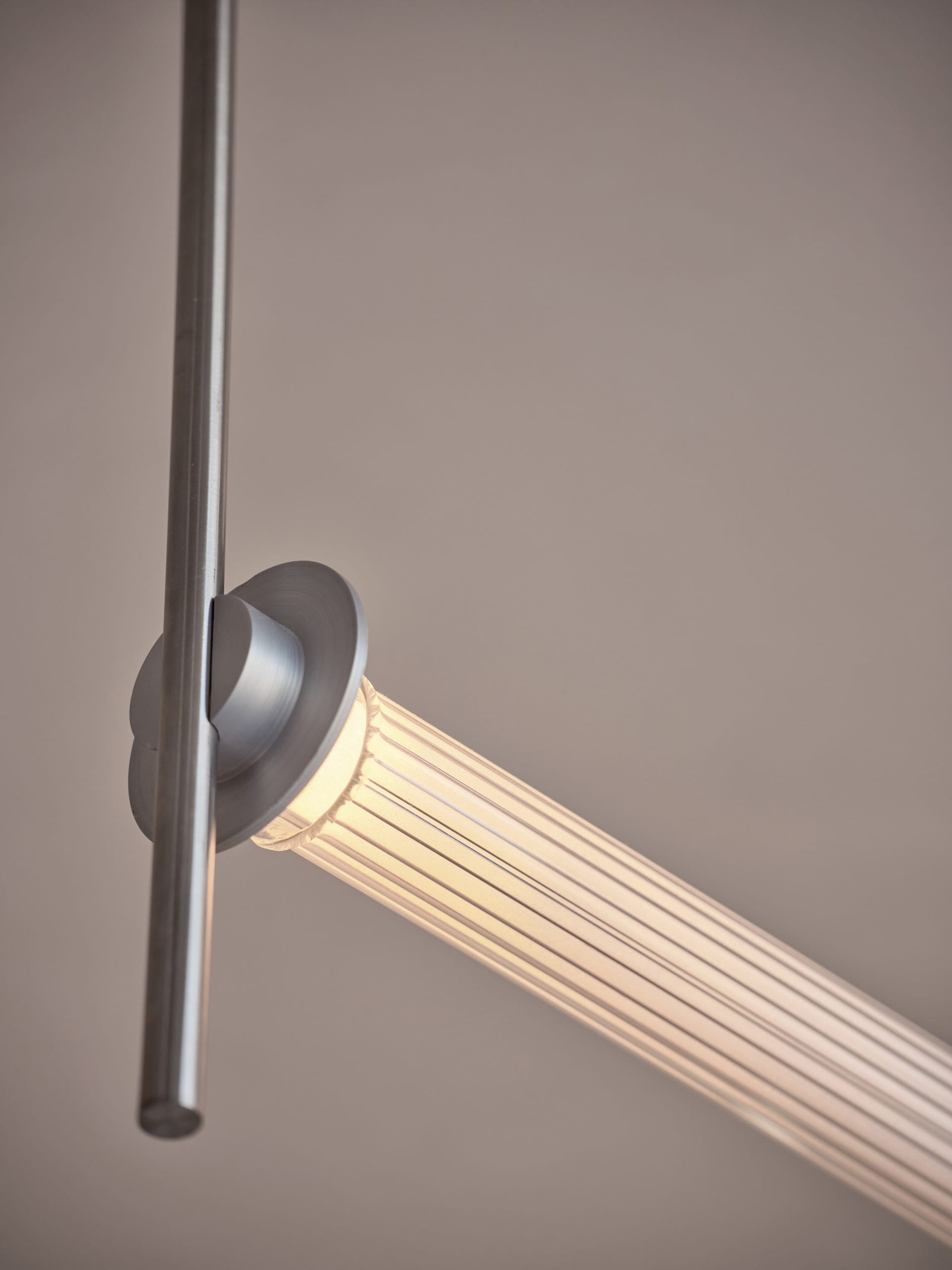 A dimly lit room with a long silver pole extending across its width, with no other objects or details visible