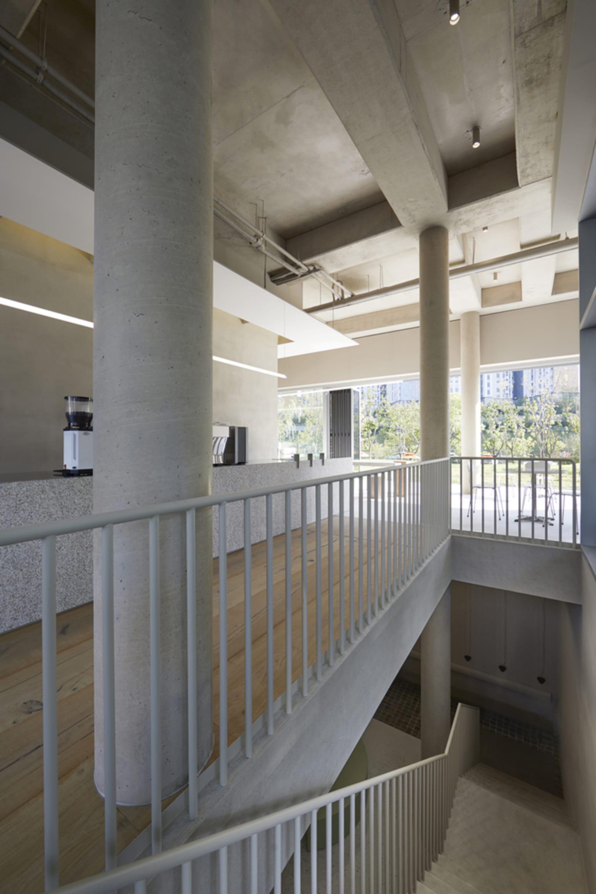 Open modern space with metal railings on two sets of stairs, clean lines, and simple design elements, well lit by natural light