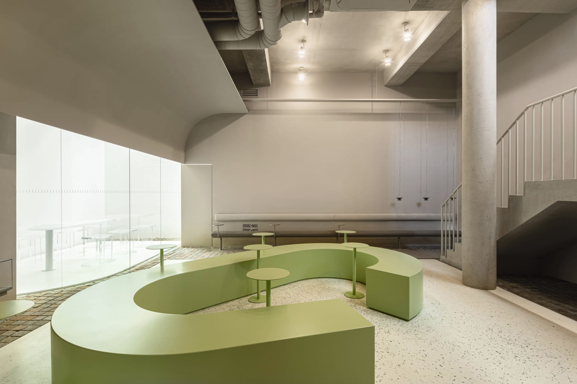 Inviting open space with a large green bench and multiple chairs, creating a comfortable atmosphere for relaxation and socializing