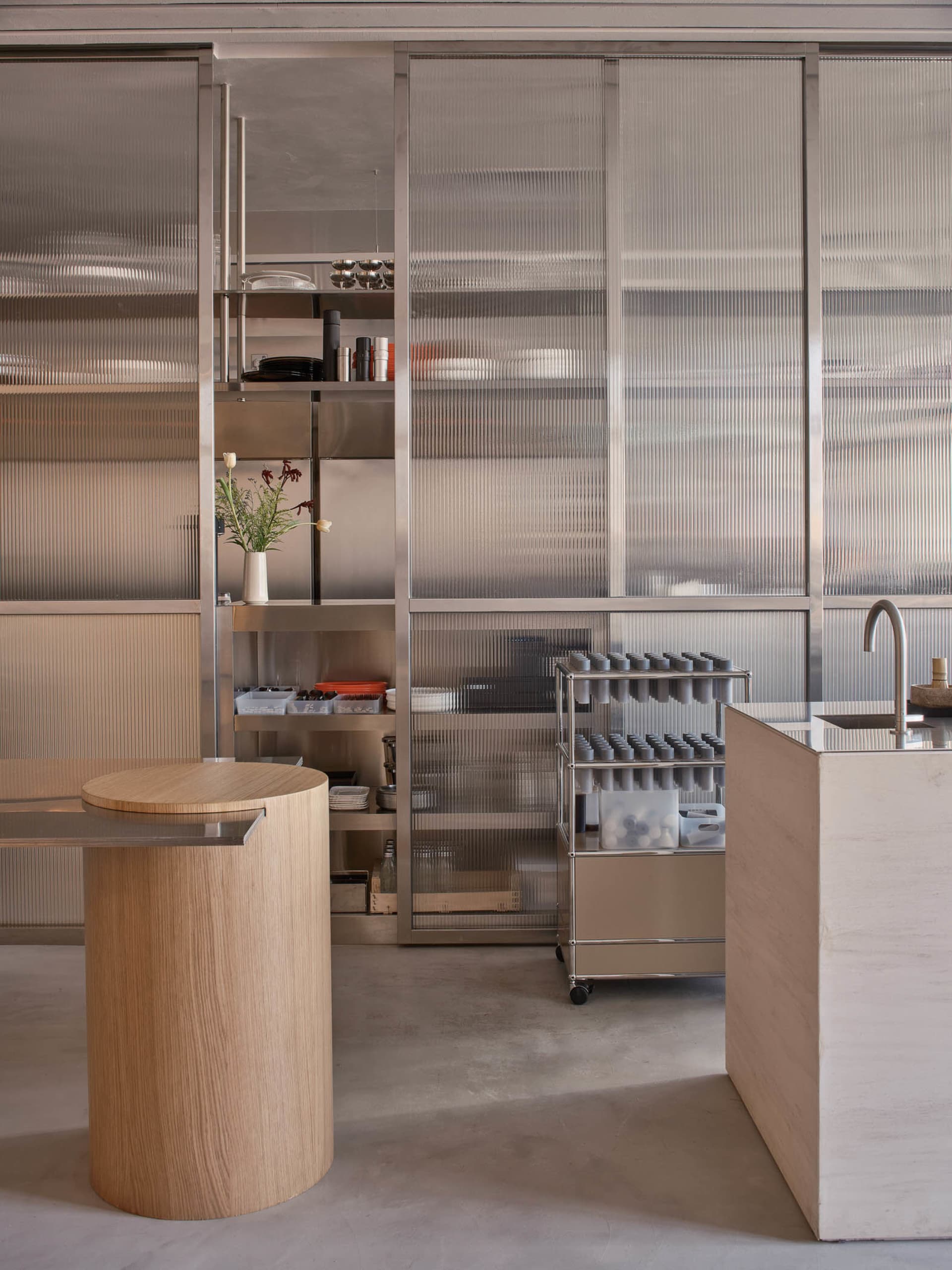 Open kitchen area with a wooden countertop, appliances, and decorative bottles, featuring a clean and organized atmosphere with a focus on functionality