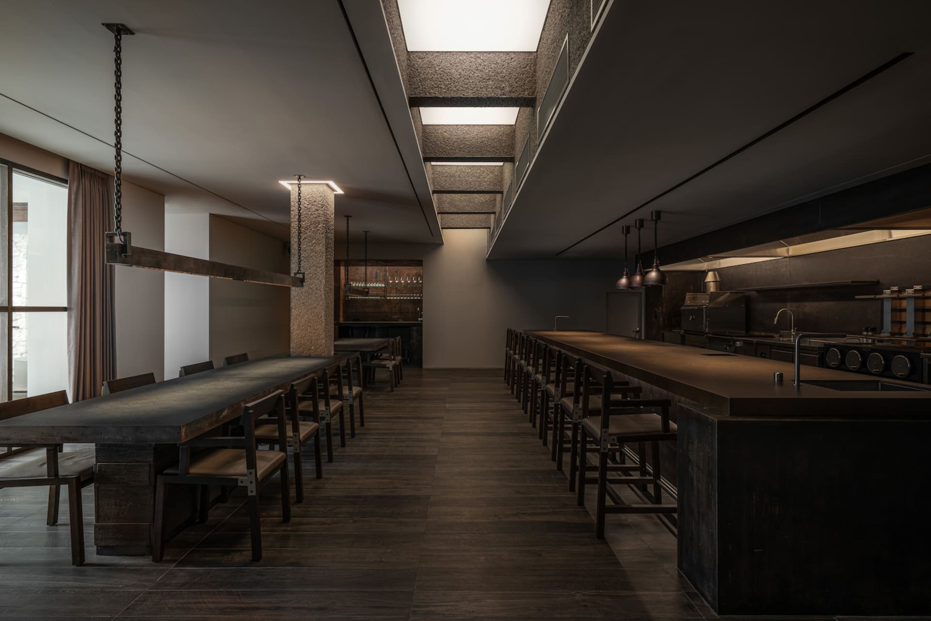 Cozy restaurant dining space with a wooden table, stone elements, and dim lighting